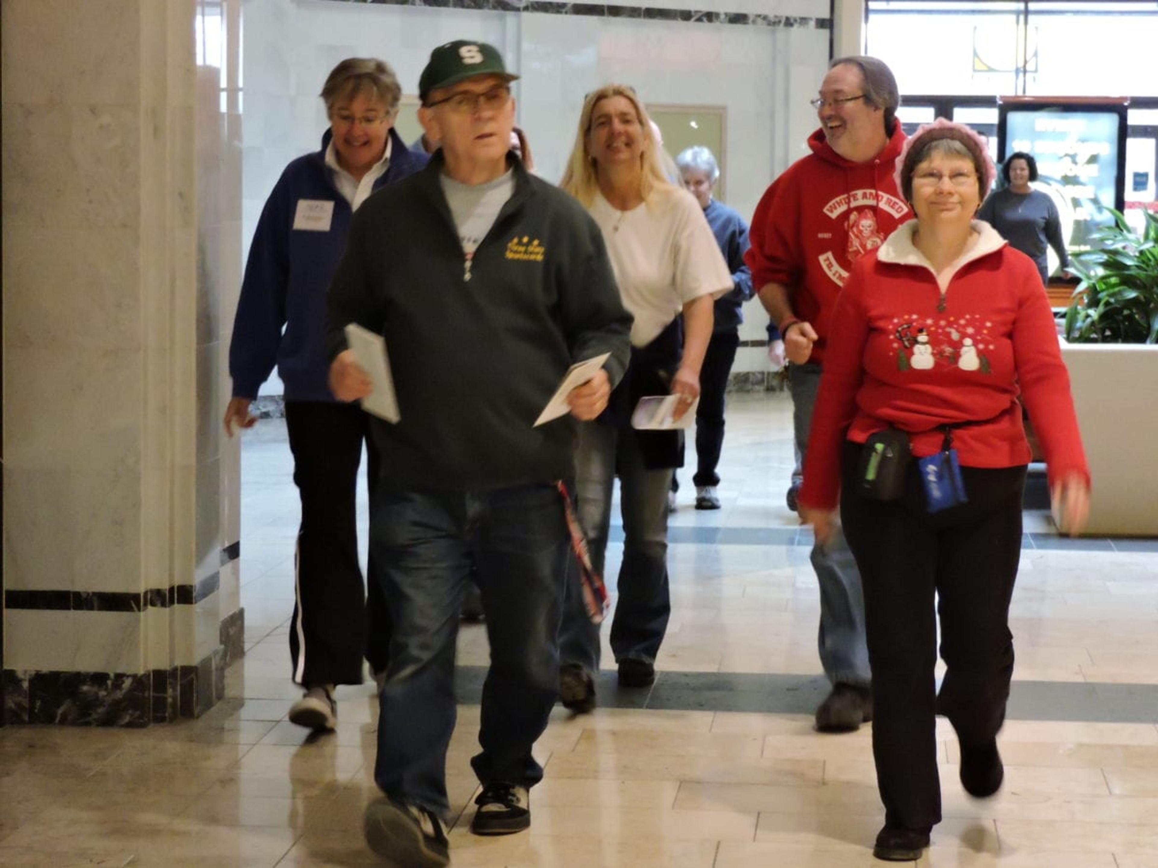 In background: Fred Garrett walks with his wife and Dr. Maude Guerin.