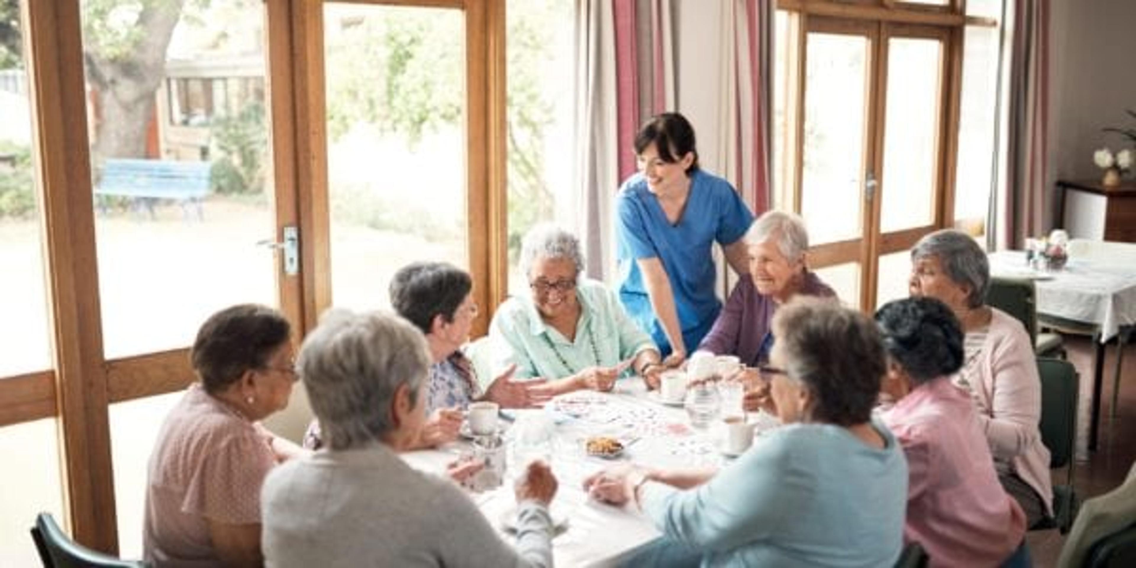 Group of seniors sitting down together at an assisted living facility