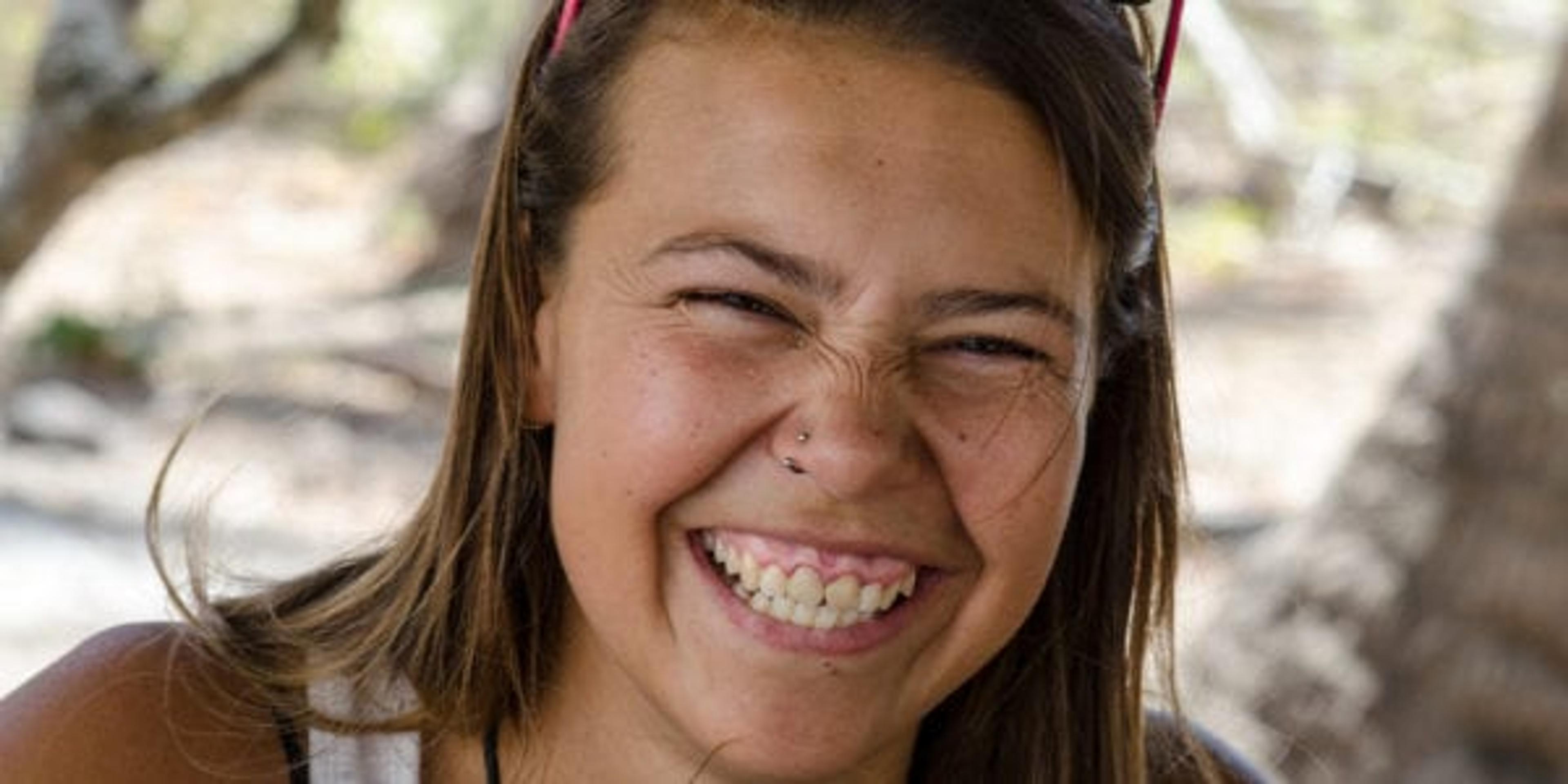 A girl outside who is giving a big smile