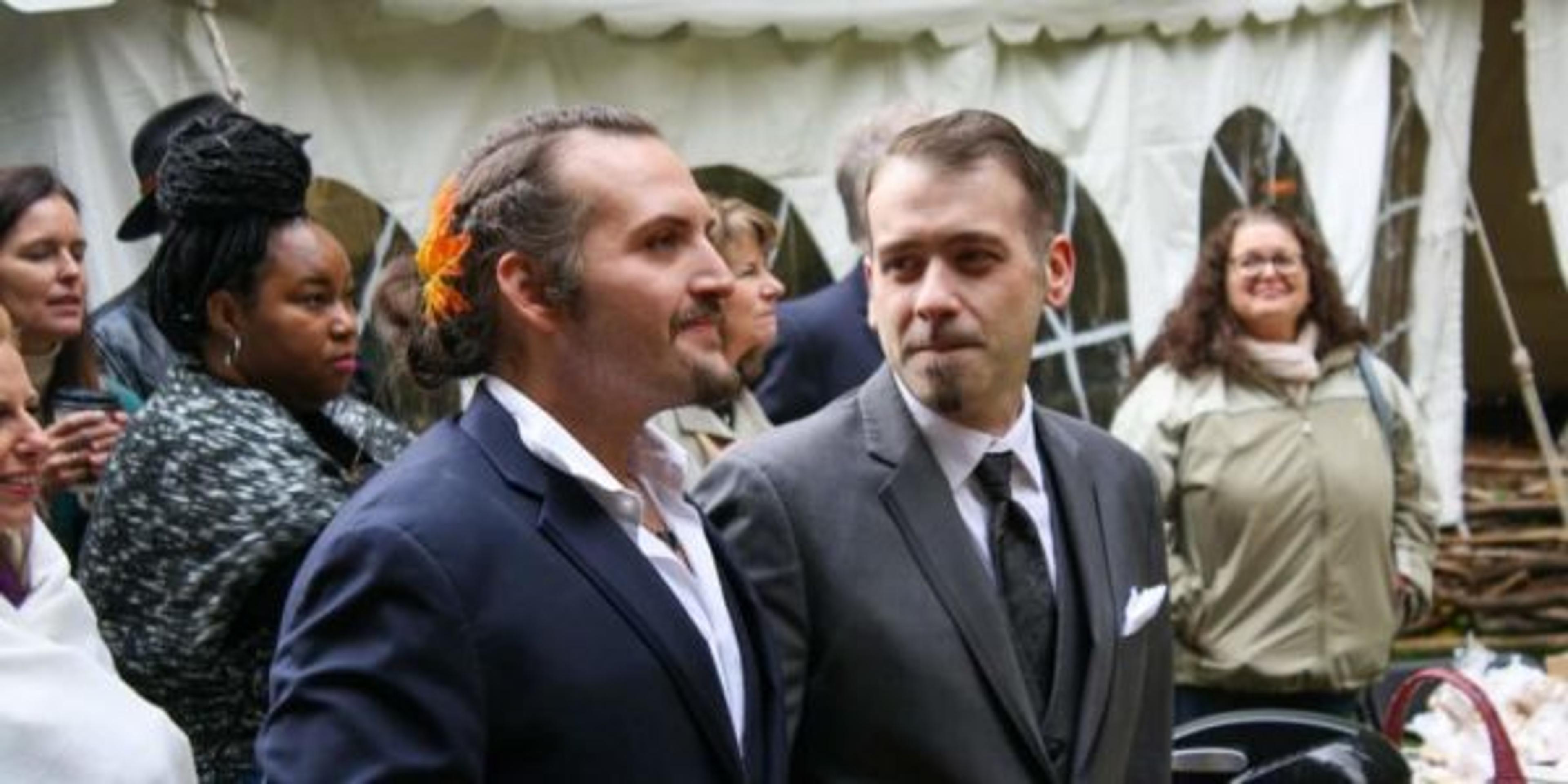Two men stare at each other lovingly during their wedding ceremony