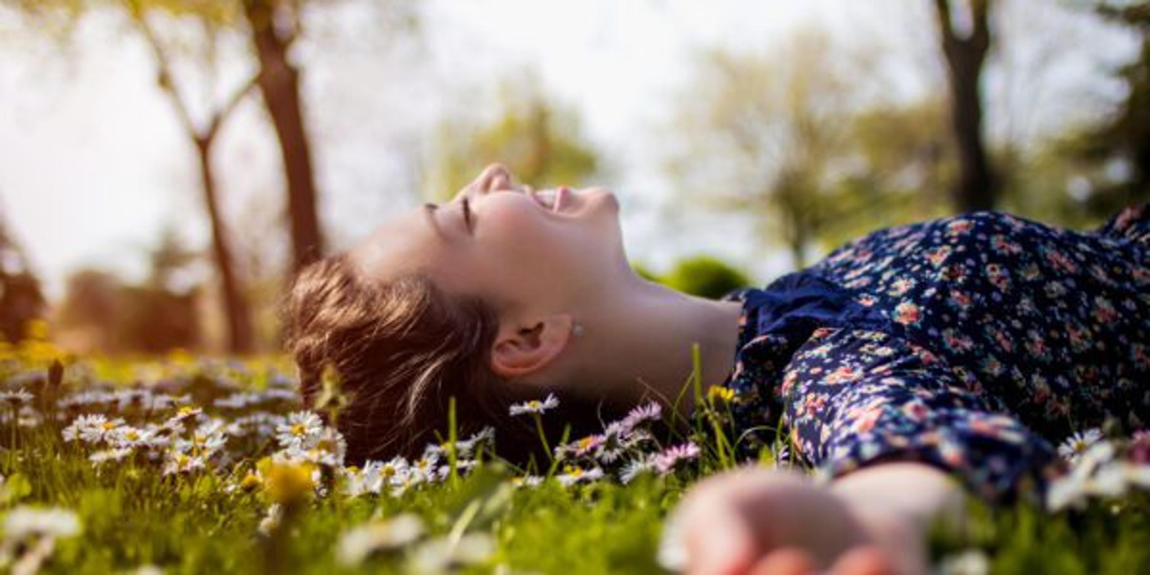 Pretty young teenage girl relaxing on a grass