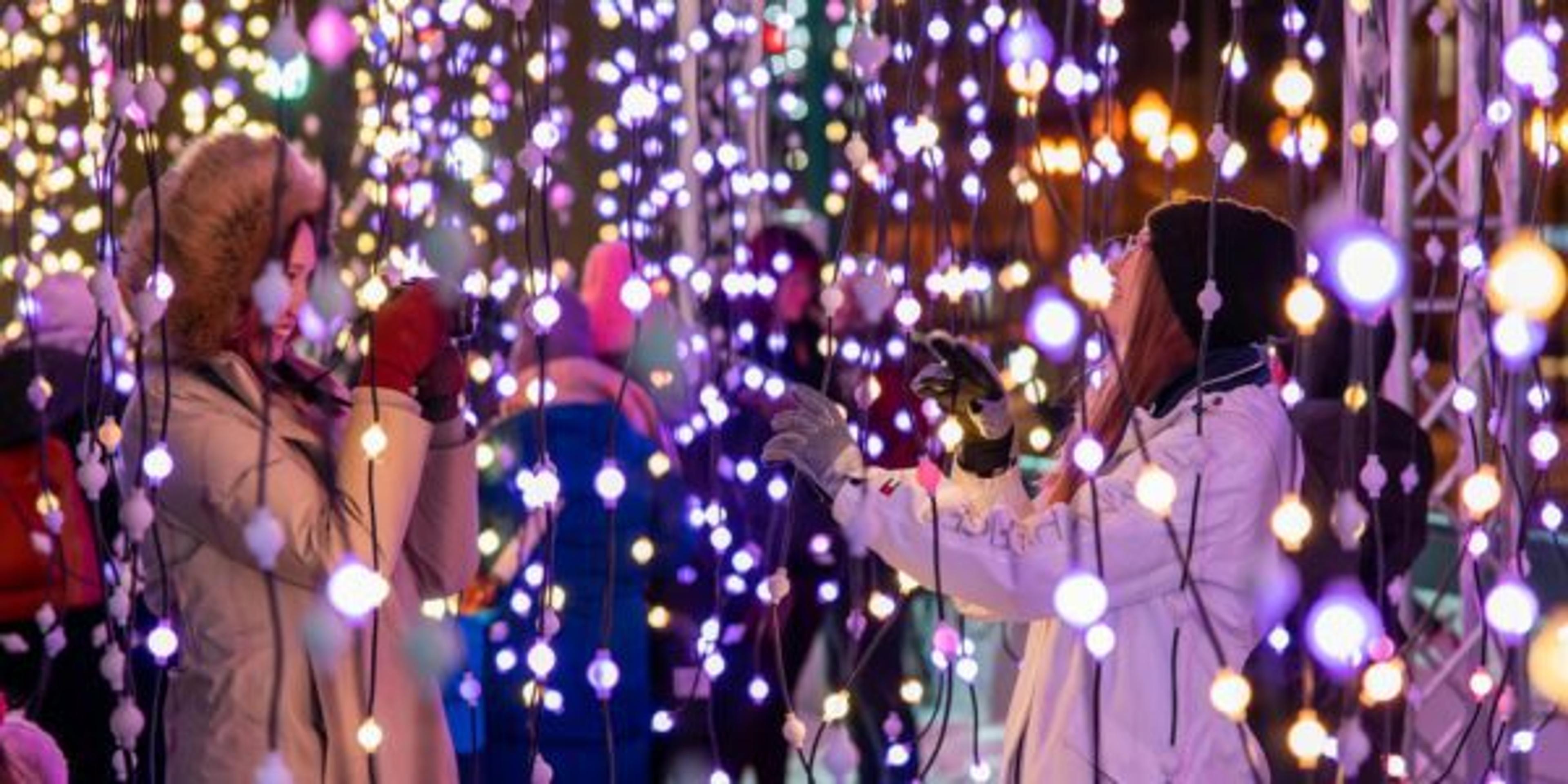 Woman captures a photograph of another woman during the Grand Rapids World of Winter festival.