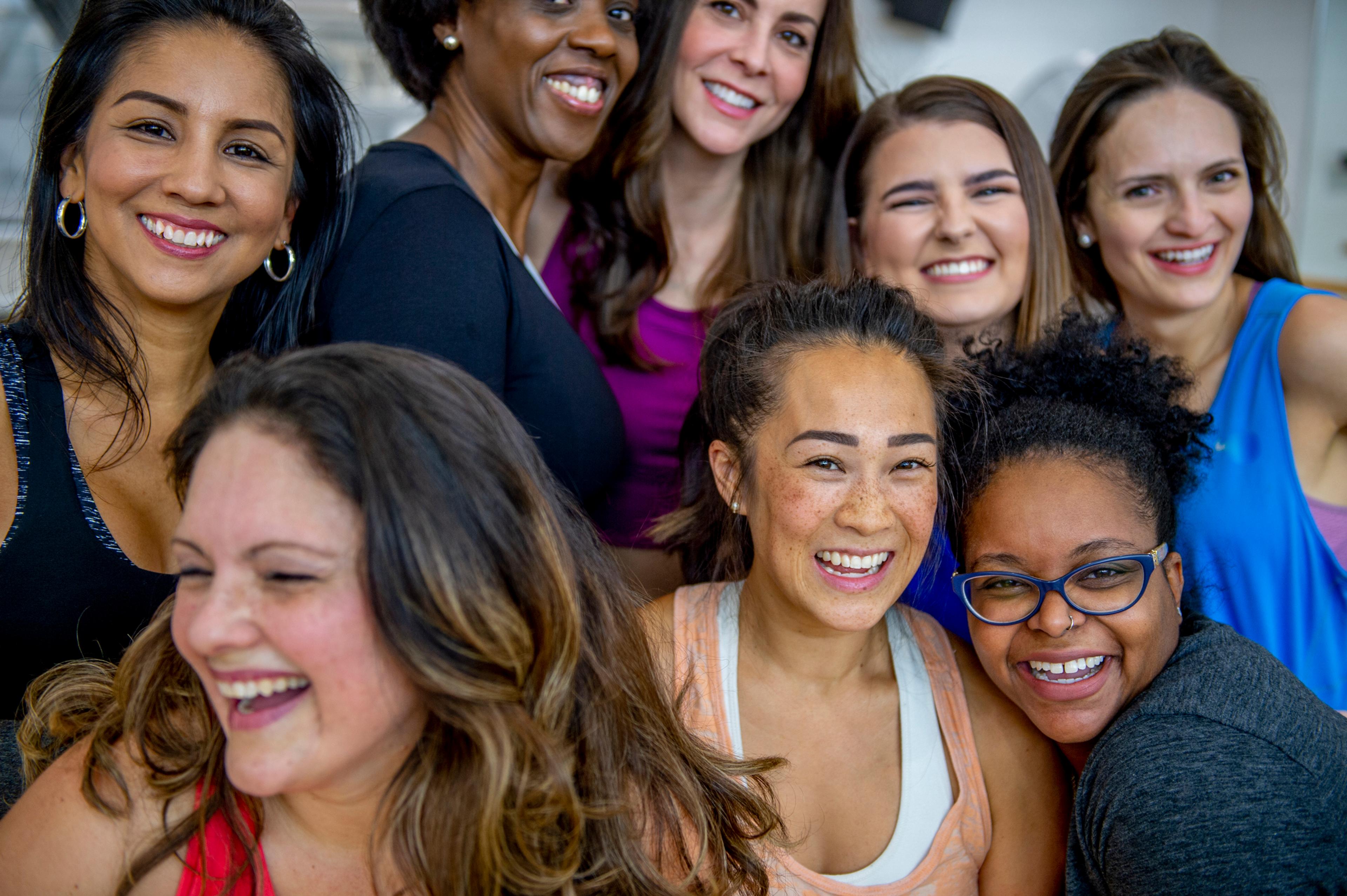 8 women together, smiling for a group picture.