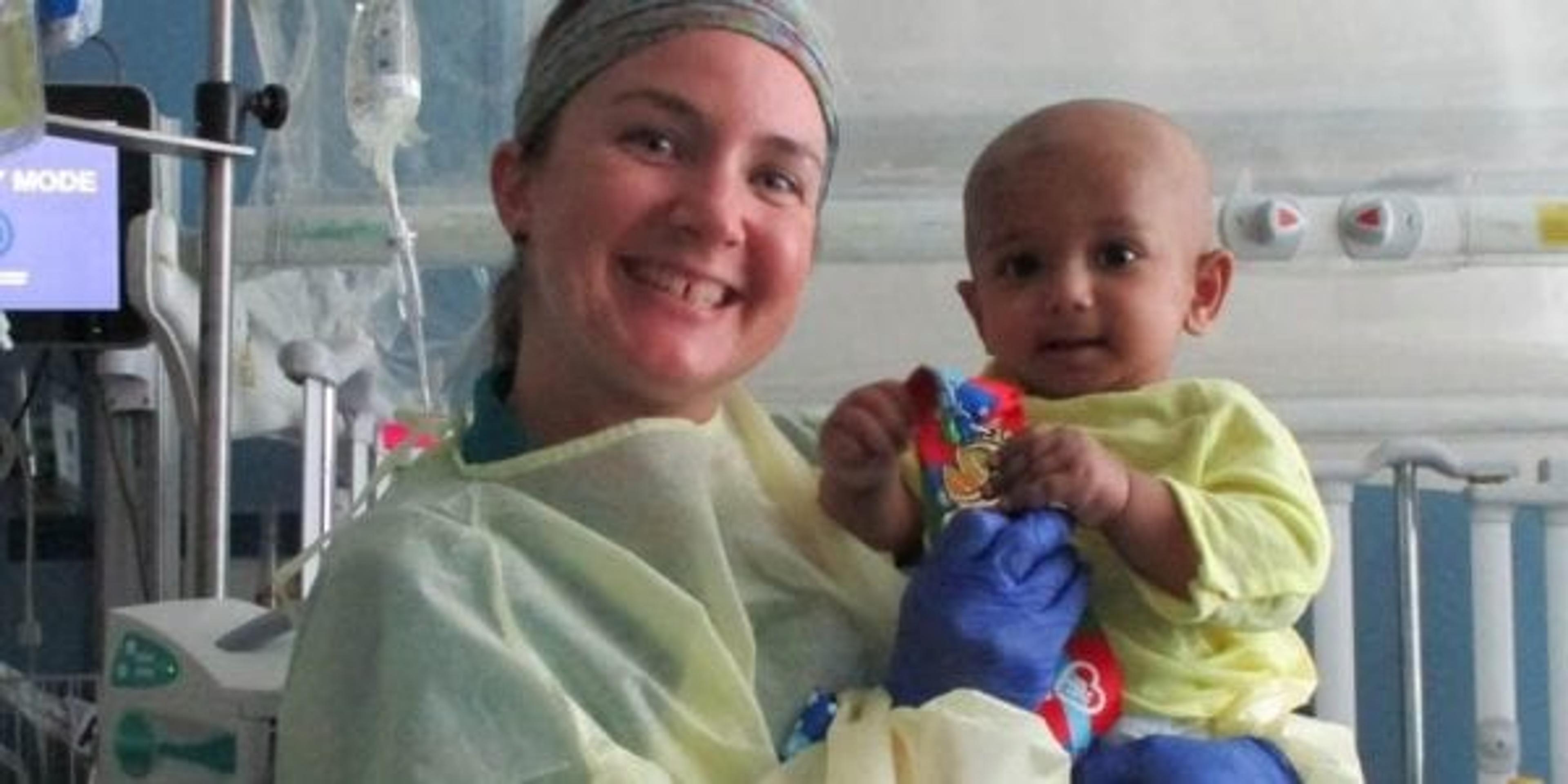 Nurse holding baby with medal