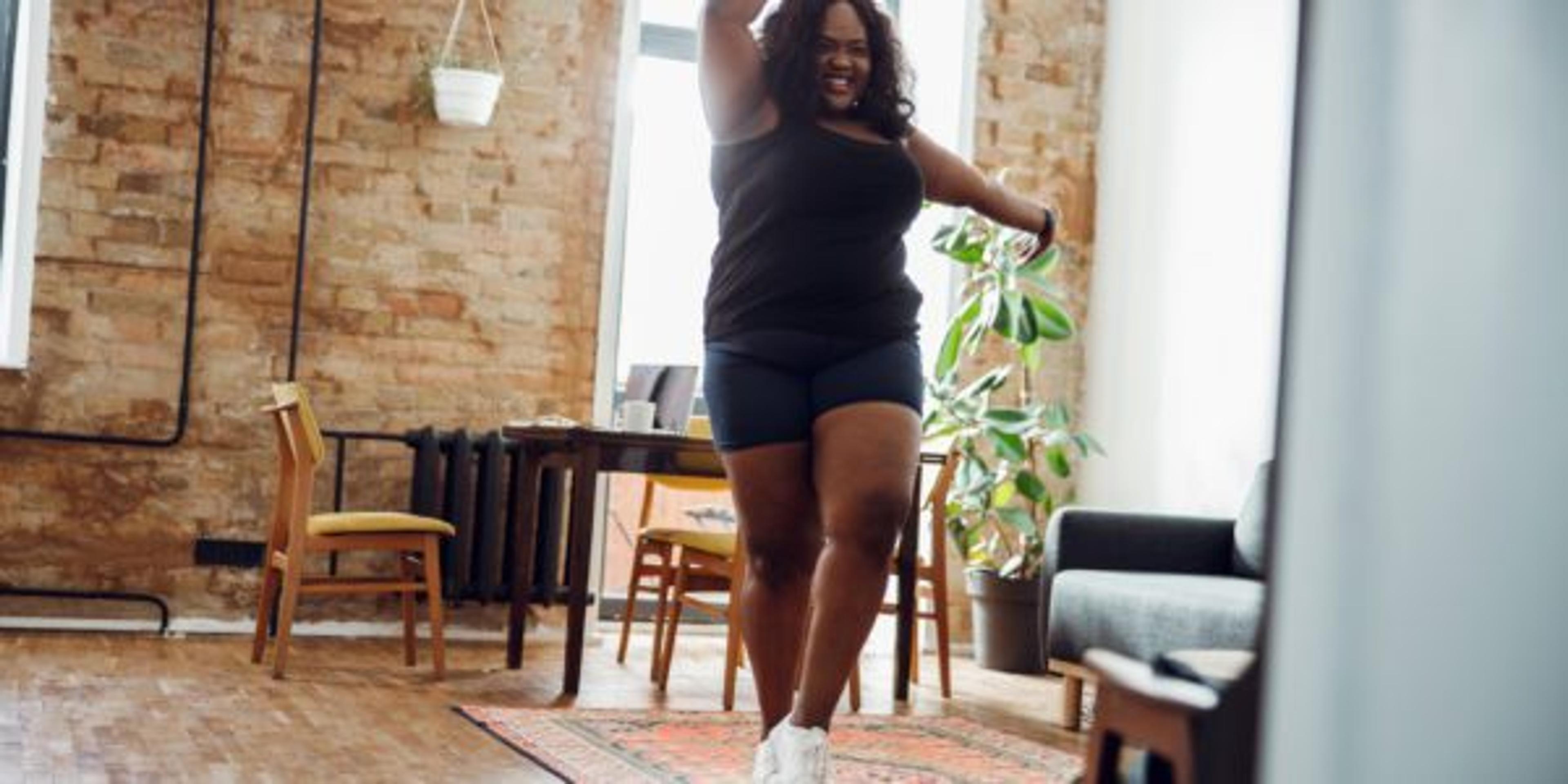 woman dances alone in her apartment as a non-diet way to keep a healthy weight