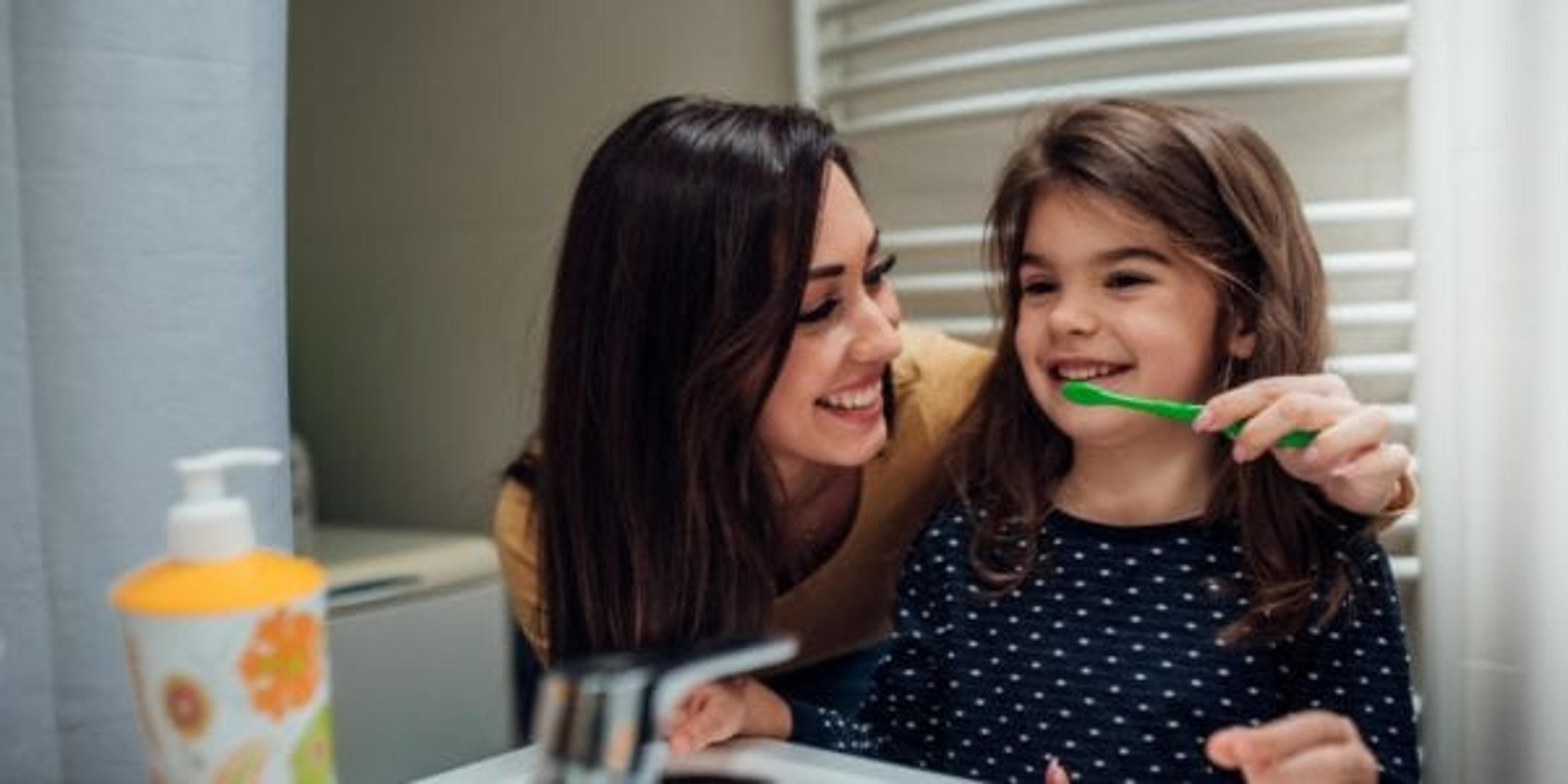 Mother and daughter brushing teeth