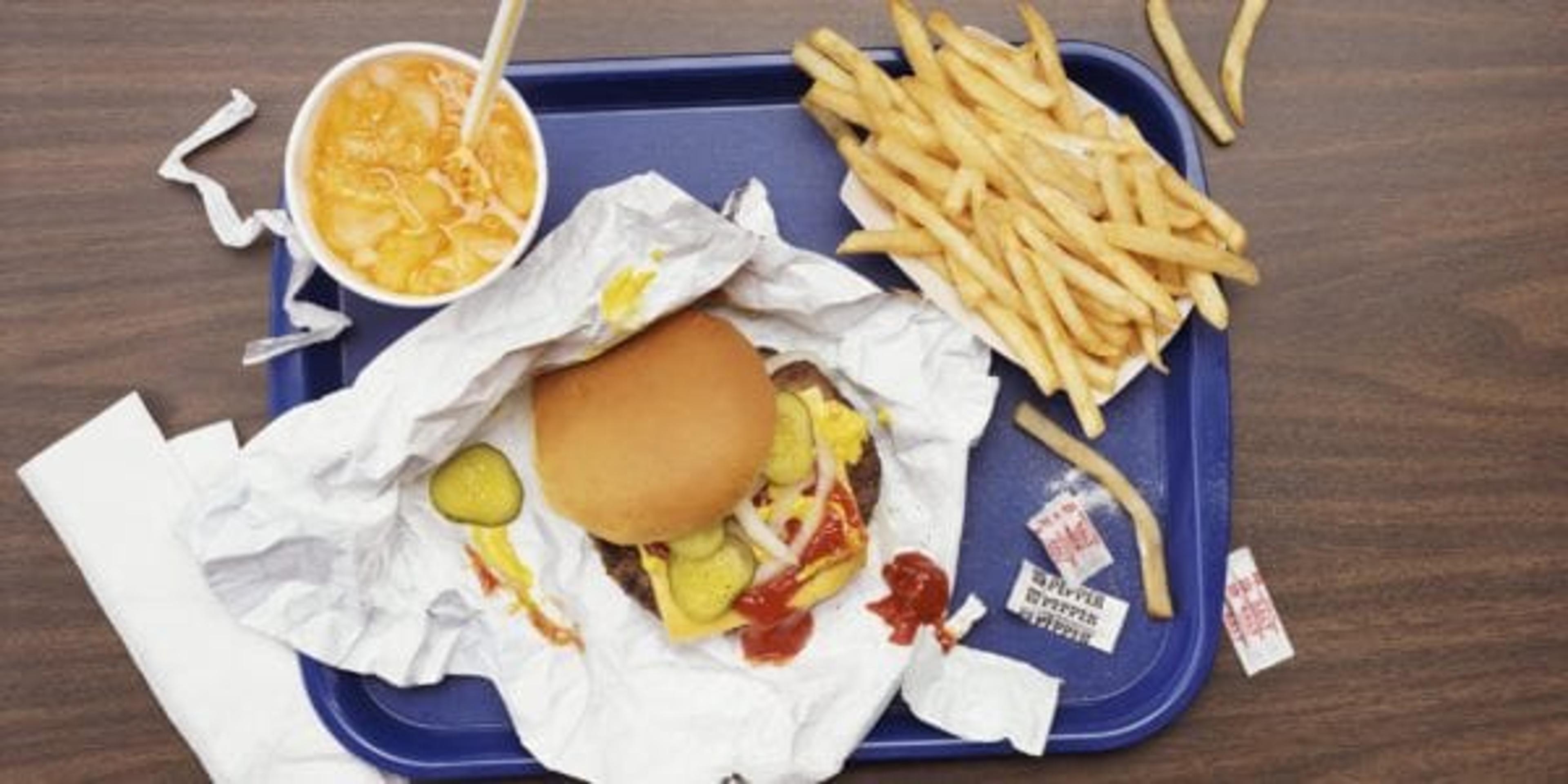Burgers, french fries, soda on a cafeteria tray