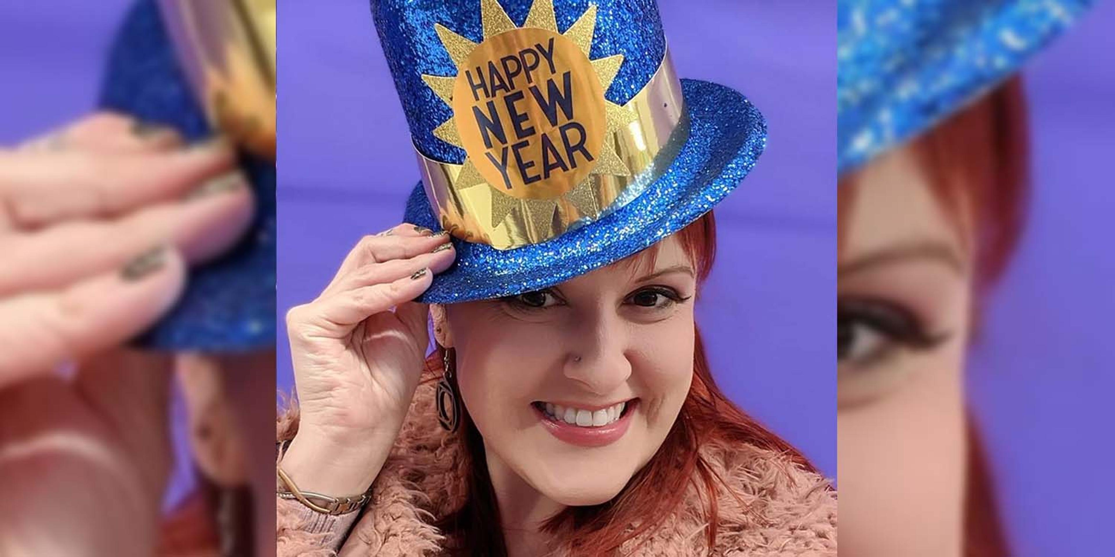 Monica Drake poses for a photo wearing a Happy New Year hat