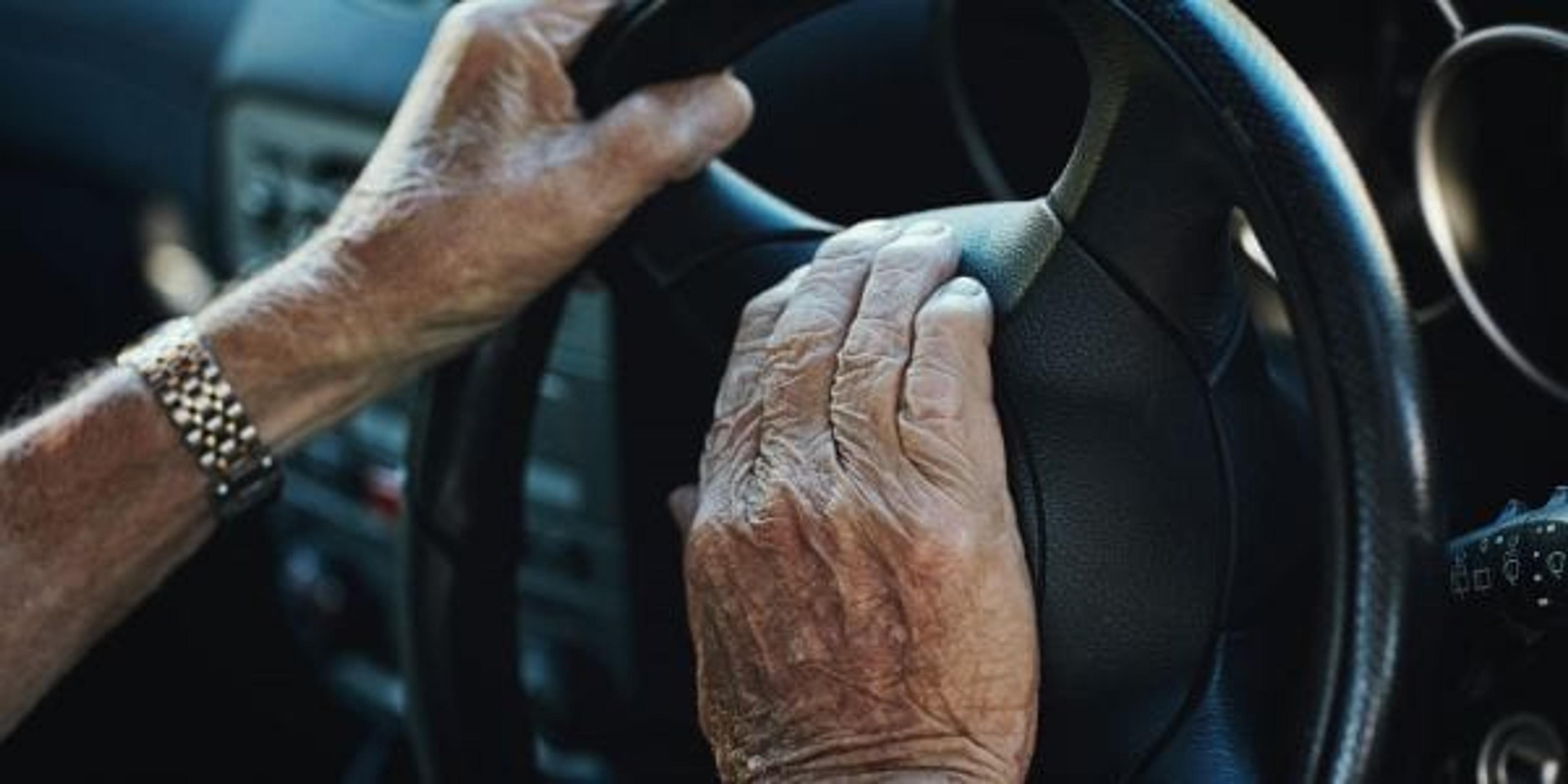 Closeup of an elderly man's hands on a steering wheeel
