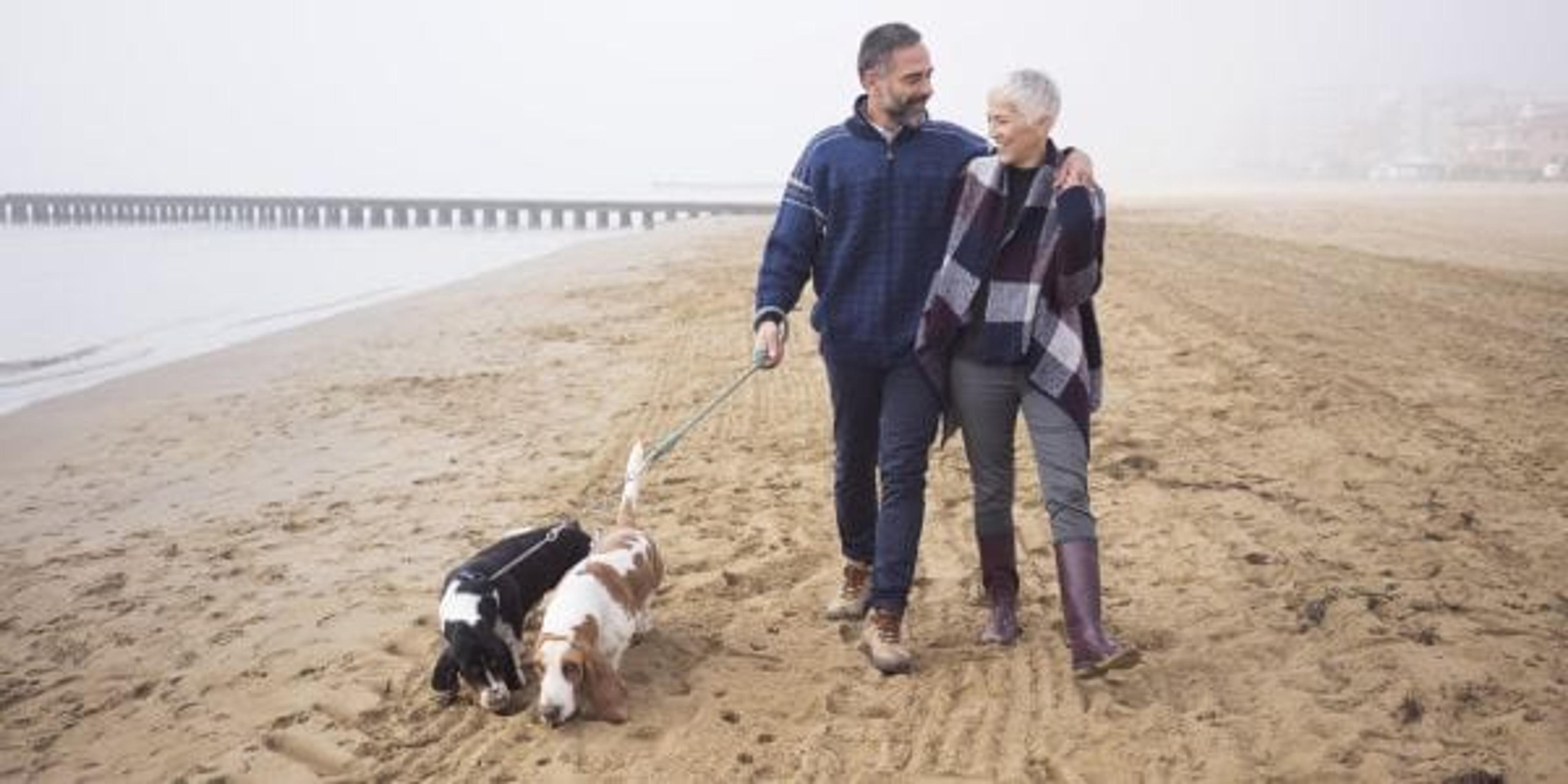 Couple in their 50s walking their dogs.