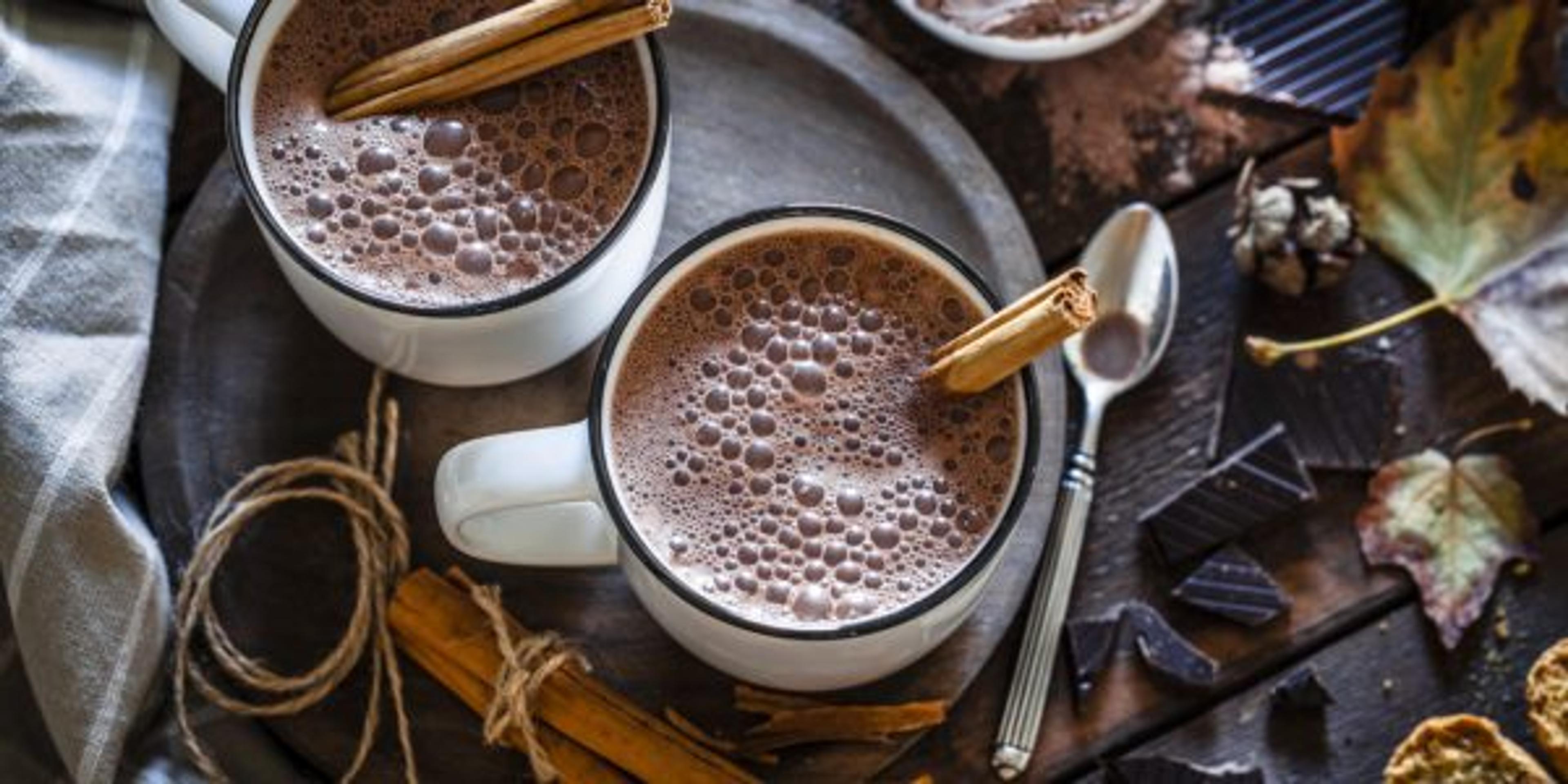 Two homemade hot chocolate mugs on rustic wooden table
