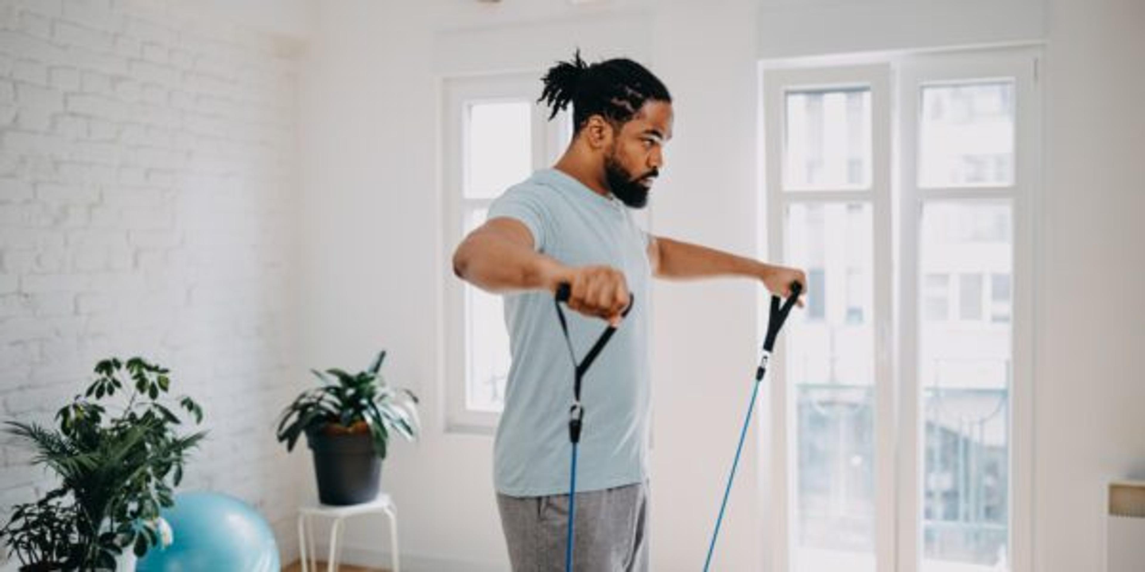 Home workout routine. Black man doing suspension straps exercises