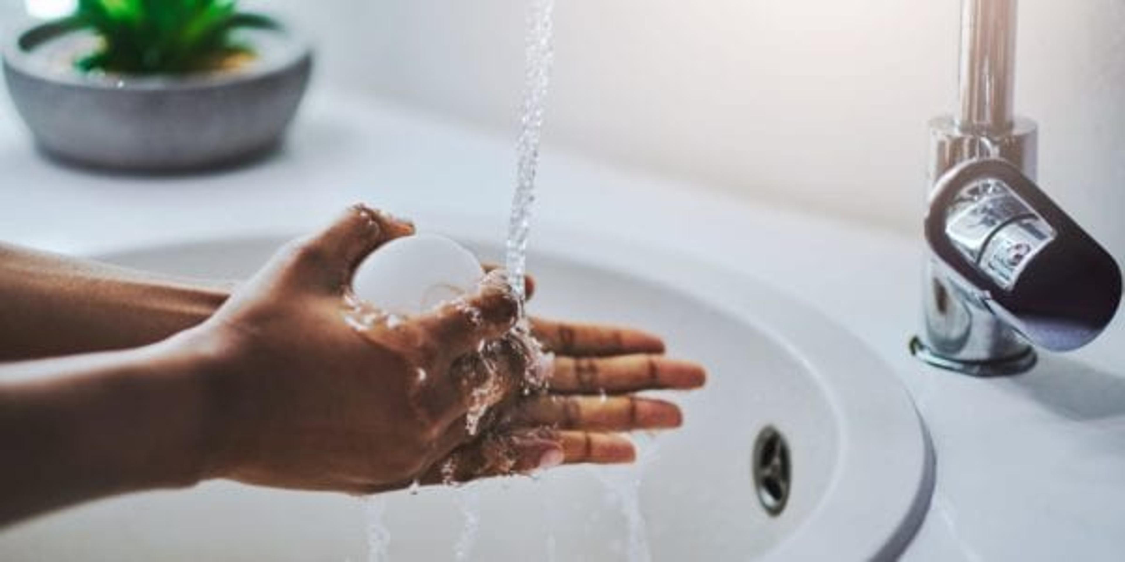 Cropped shot of a woman washing her hands at a sink with bar soap