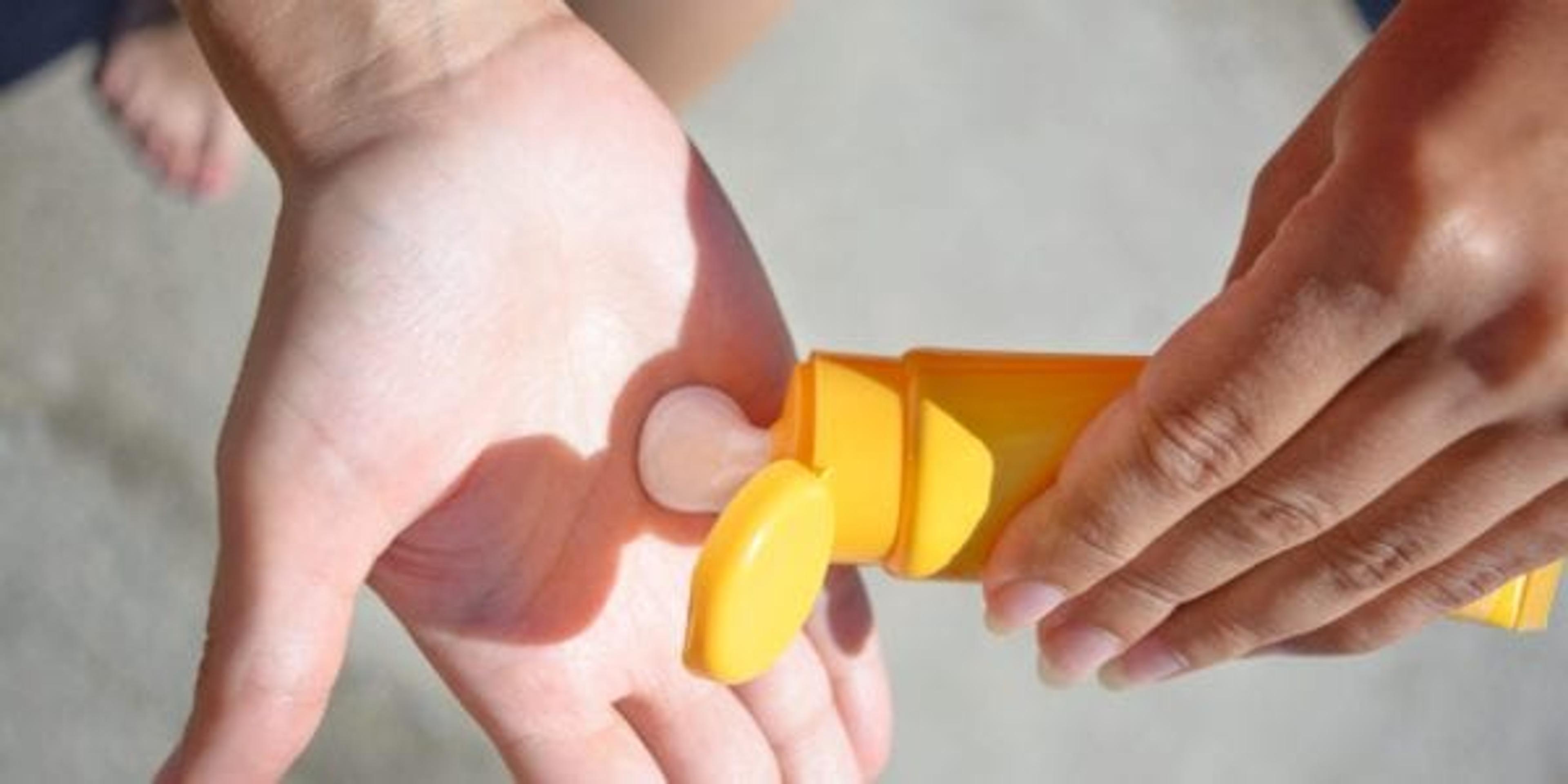 Woman putting sunscreen in her hand