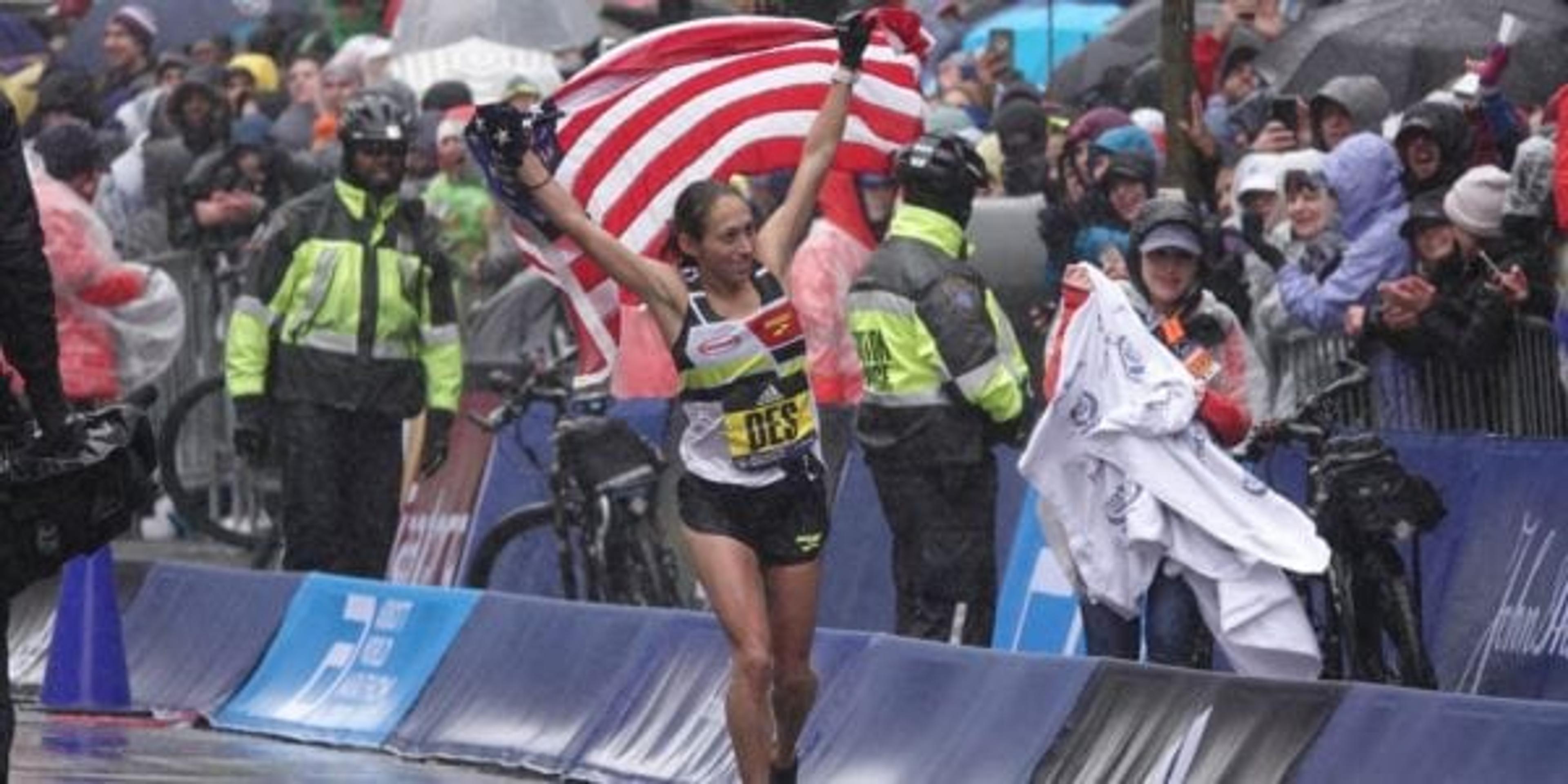 Photo of Desiree Linden holding up the American flag after winning the 2018 Boston Marathon.