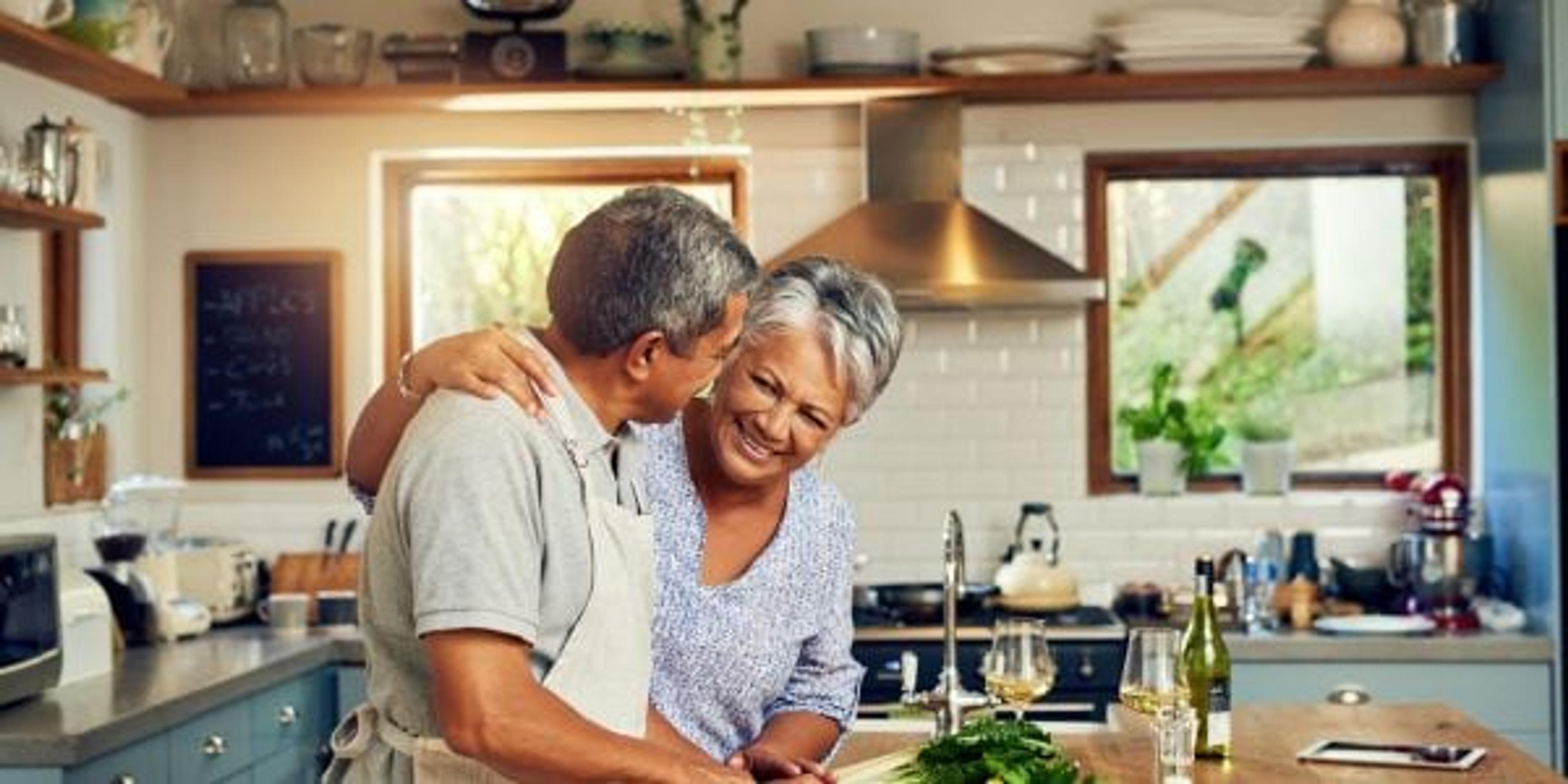 Image of happy mature couple cooking dinner together.