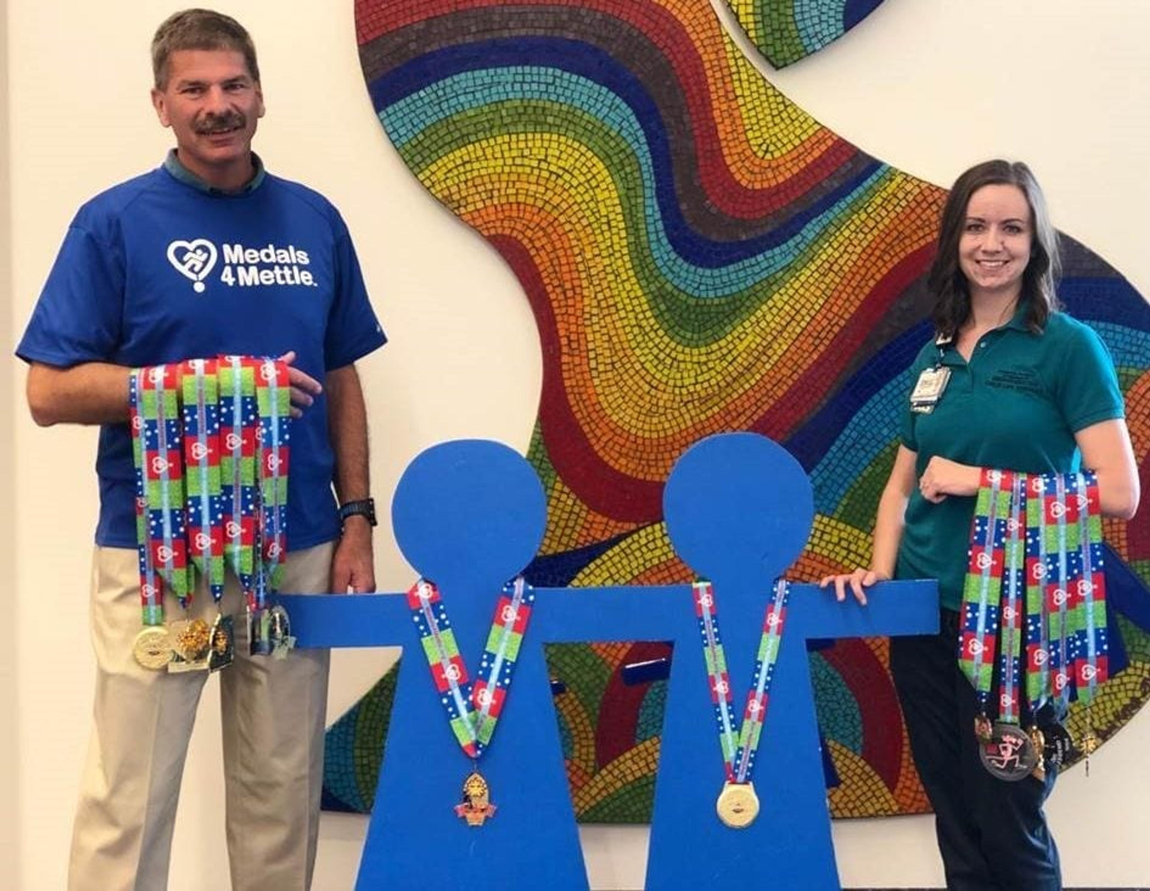 Joe Burns and Sinéad Nimmo hold medals to be given to kids in the hospital