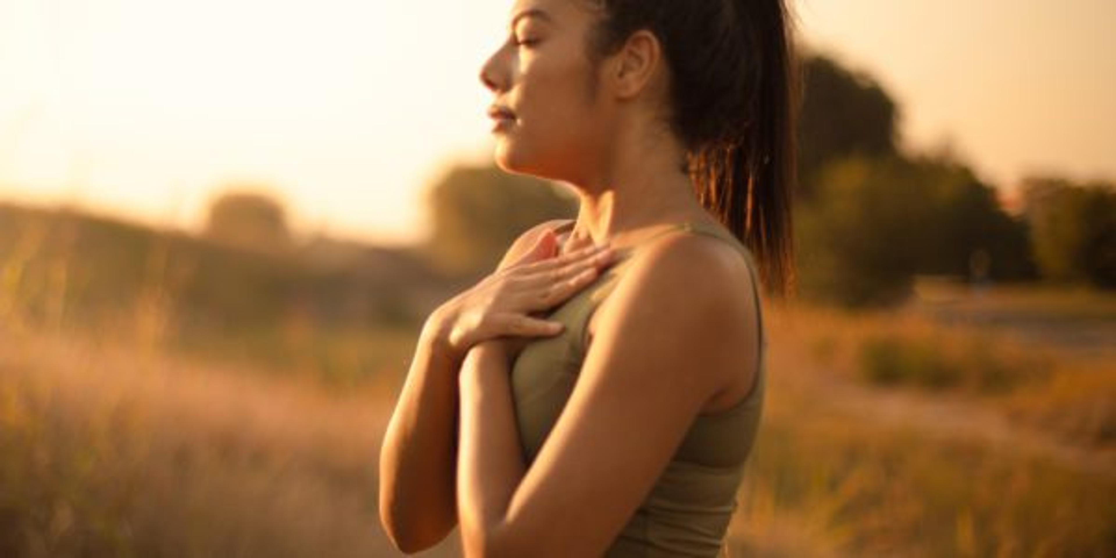 Young woman practicing mindfulness in a field