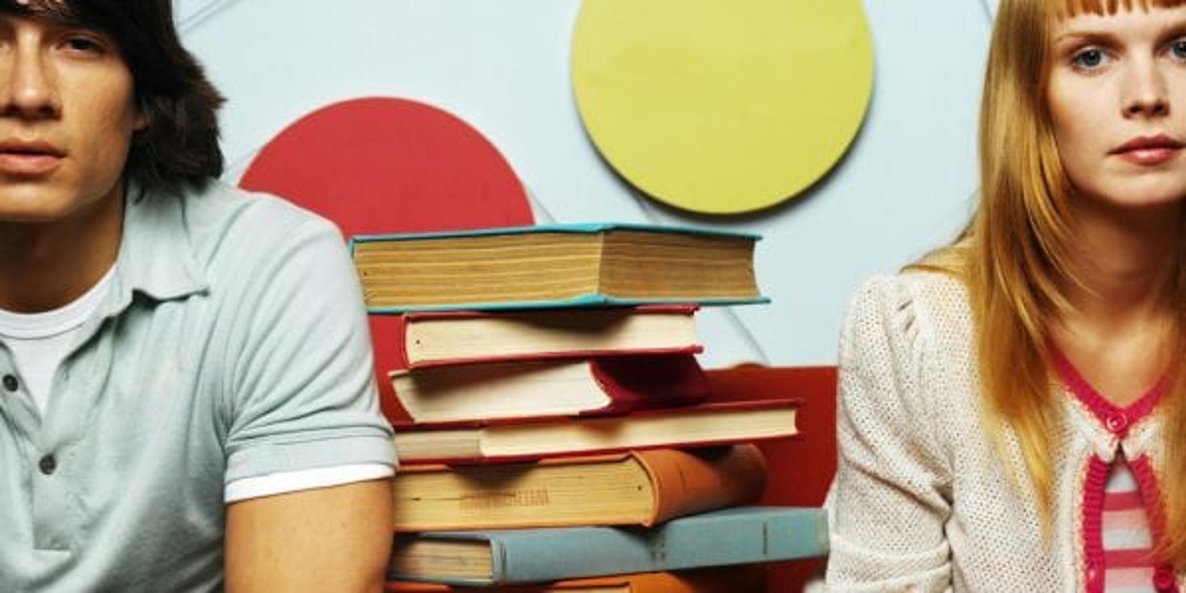 Young couple sitting with a pile of books