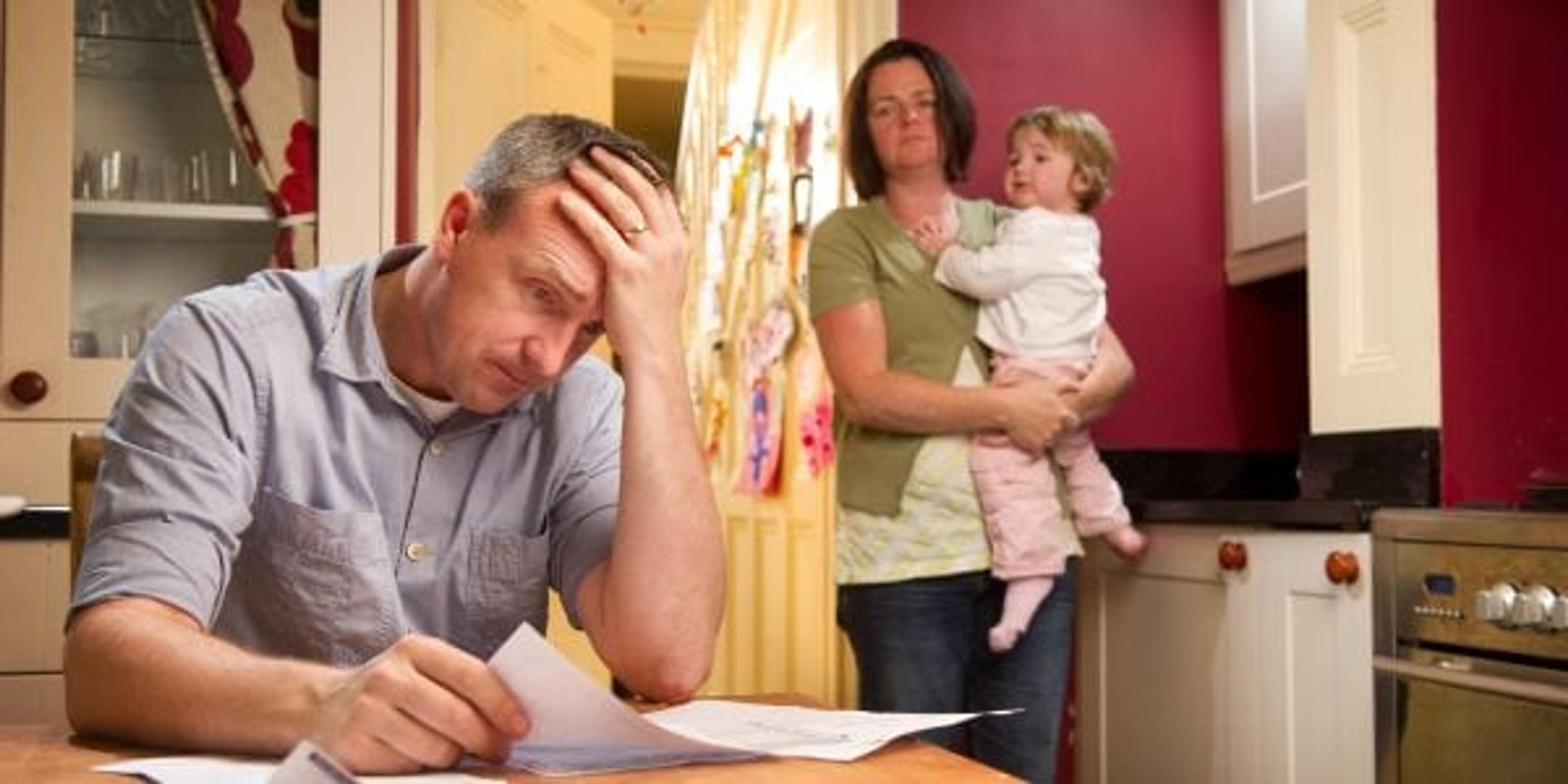 Man sitting at table stressed over bills