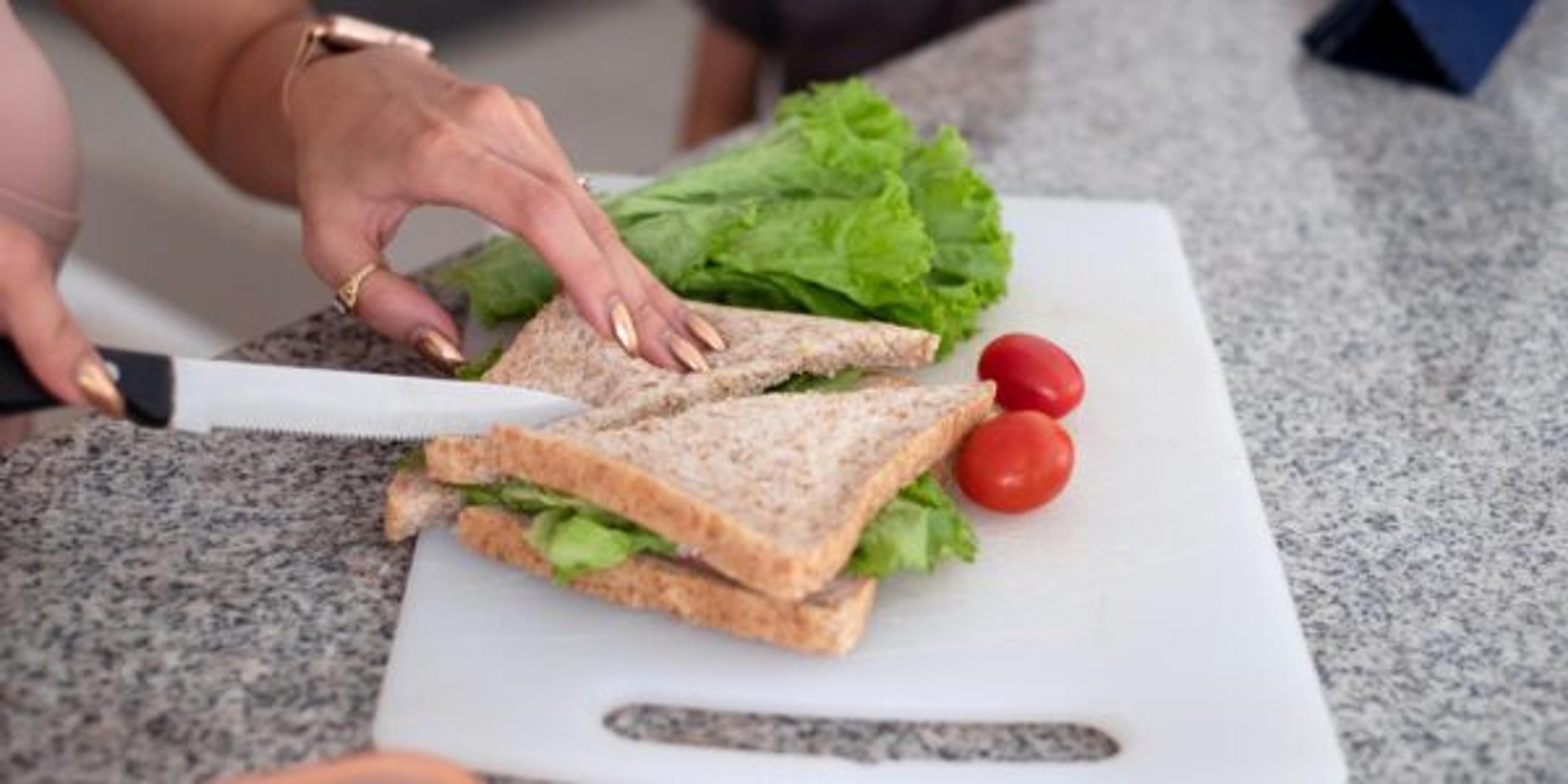 Southeast Asian Mother Making Sandwich For Her Son Breakfast