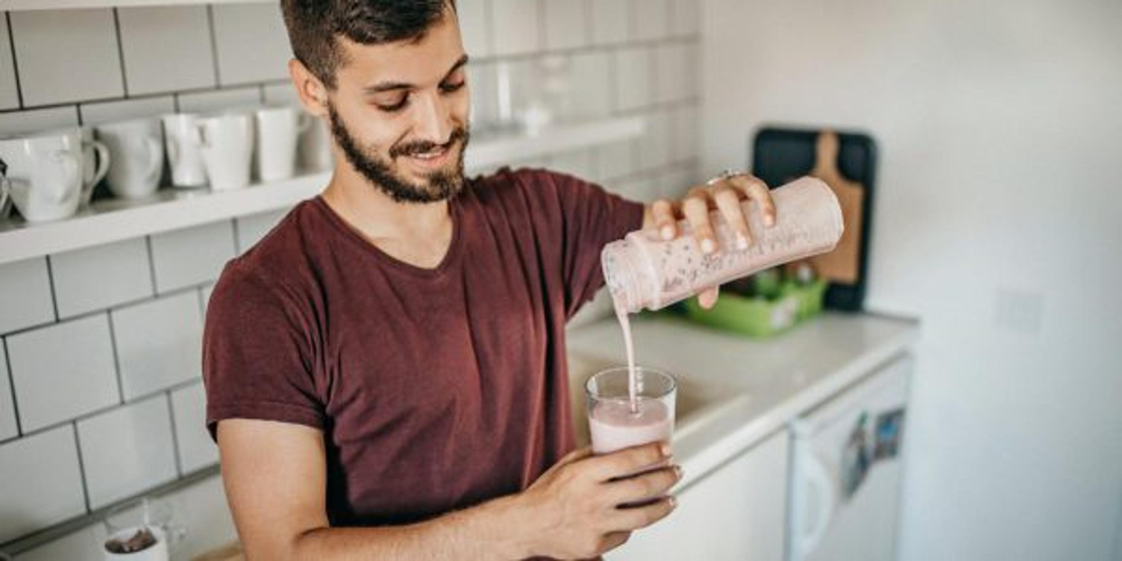 Men preparing smoothie for morning drink at home