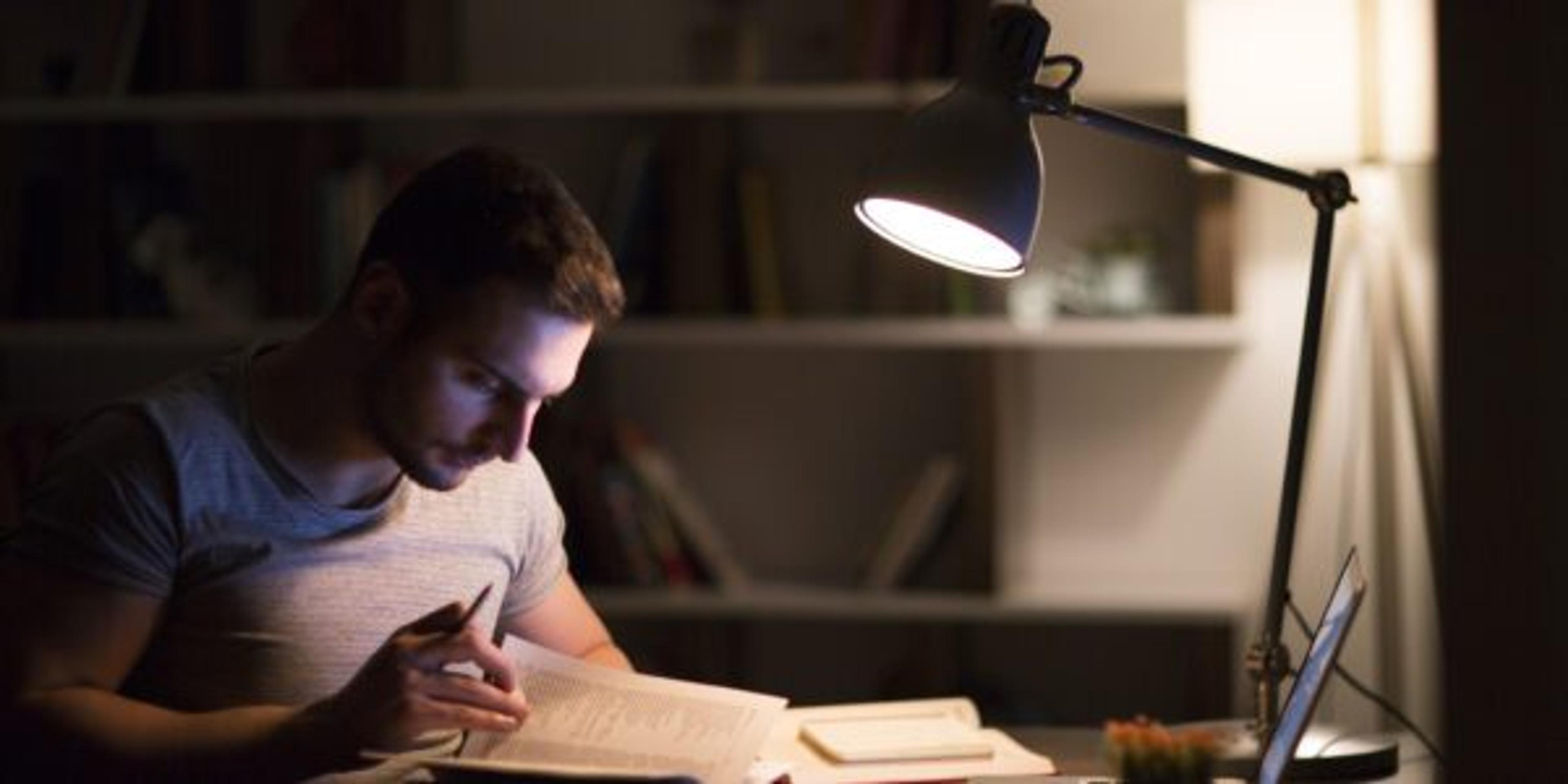 Man writes at his desk at night