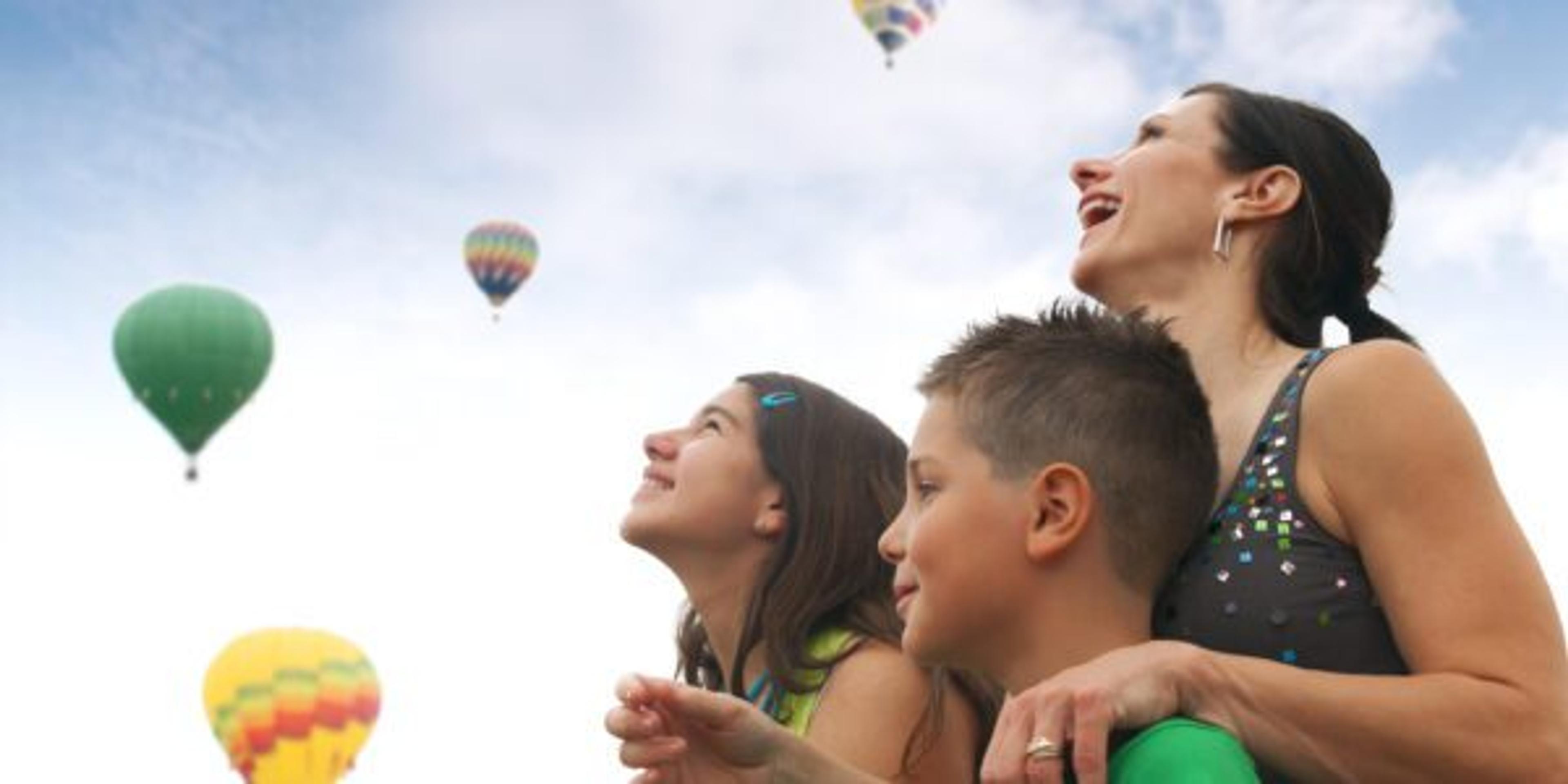 Family watching hot air balloons during a Michigan summer festival