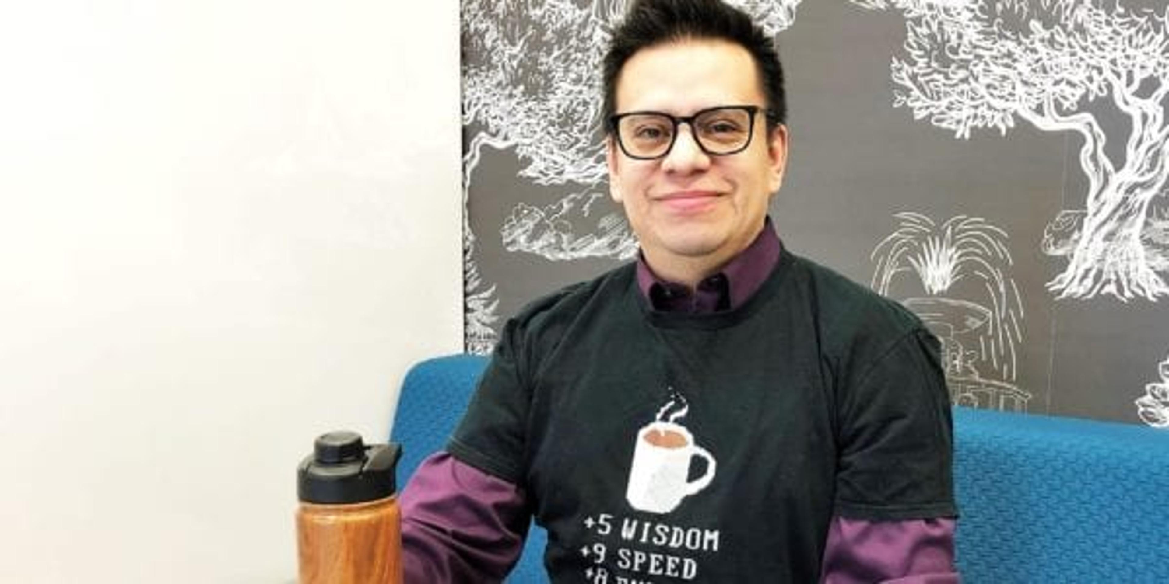 David Murray poses for a photo in his favorite coffee t-shirt with his water bottle.