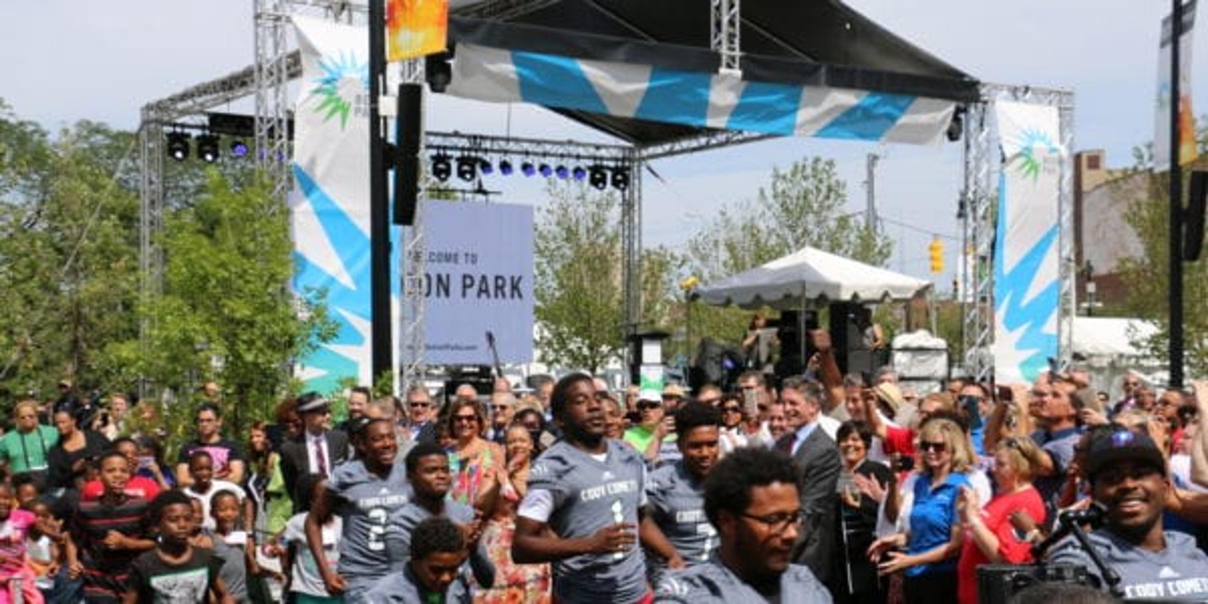 Local high school Football team runs through through the Beacon Park grand opening banner to officially open the park to the public.