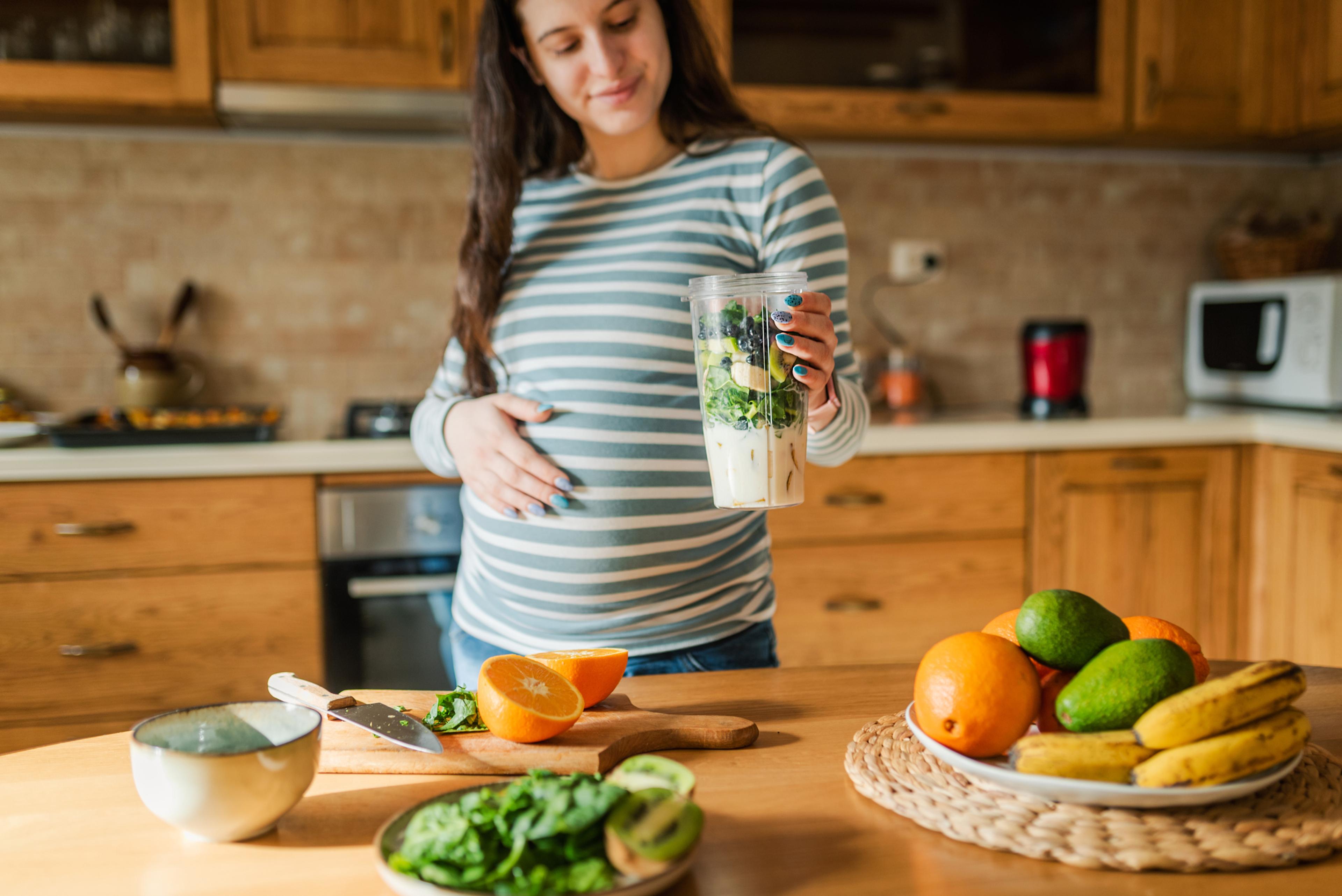 A pregnant woman preparing healthy snacks for her pregnancy.