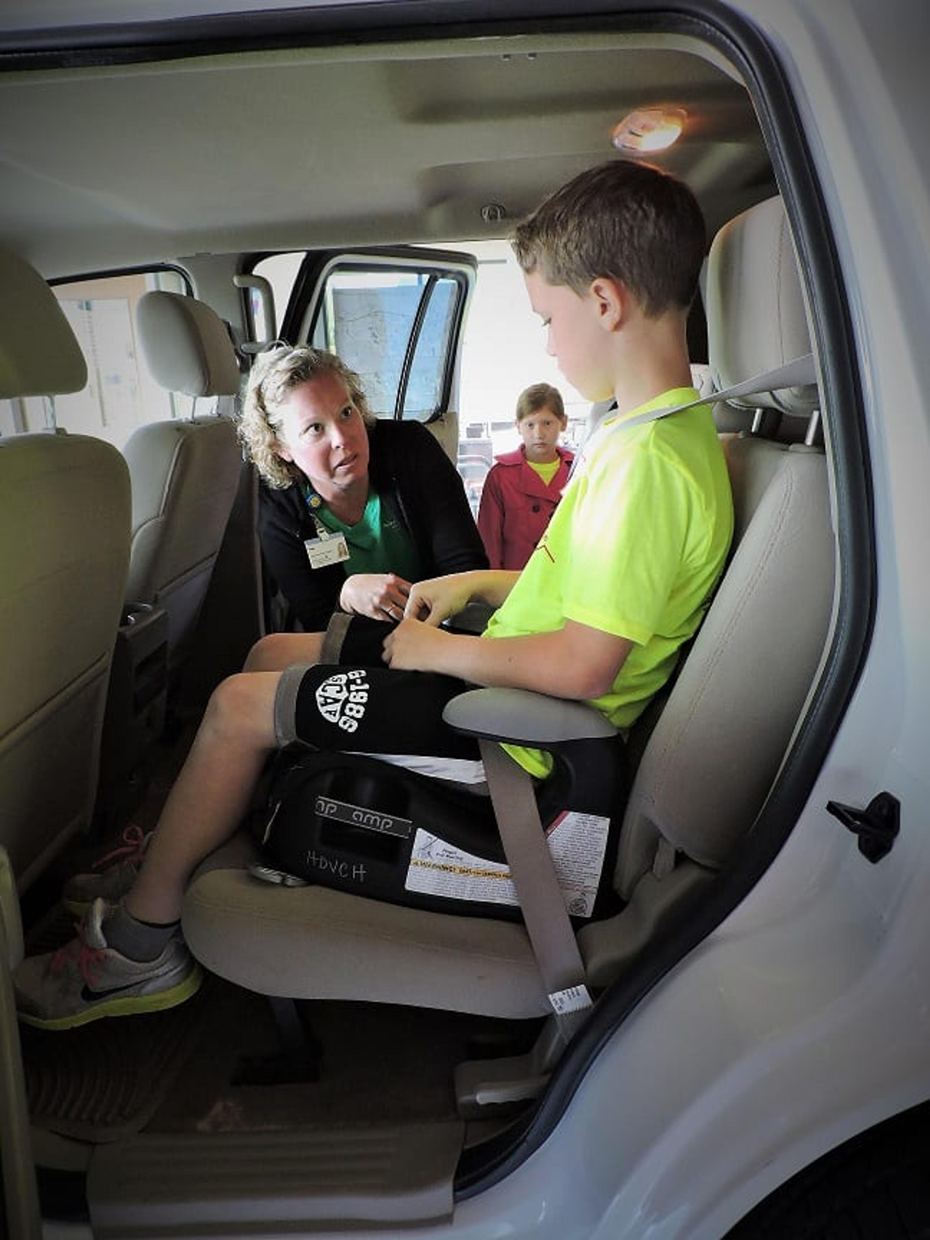 Amy Horn, an Injury Prevention Assistant with Safe Kids, checks seat belt fit with a Life EMS Camp 911 camper at the Walker Fire Station.