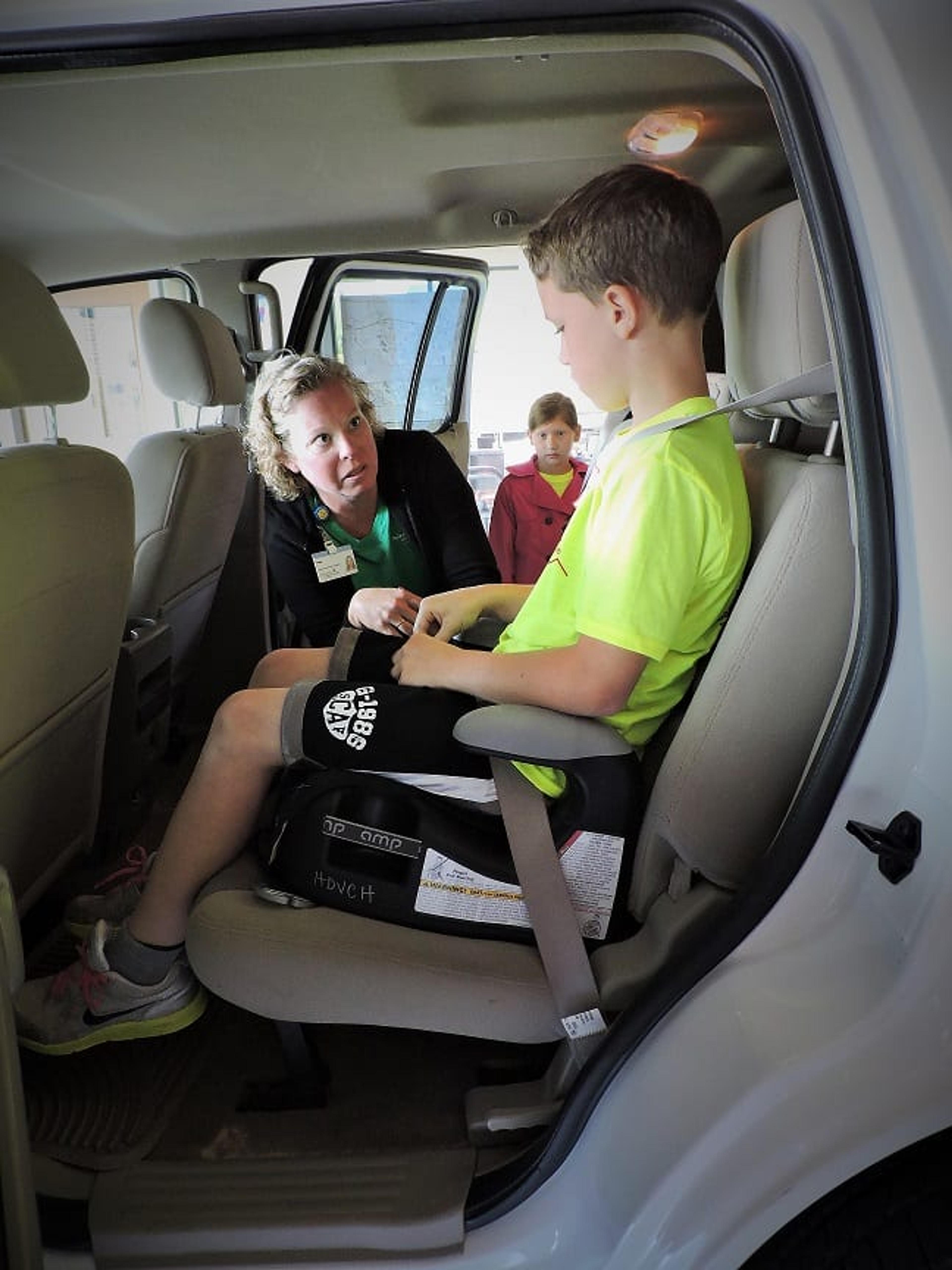 Amy Horn, an Injury Prevention Assistant with Safe Kids, checks seat belt fit with a Life EMS Camp 911 camper at the Walker Fire Station. 