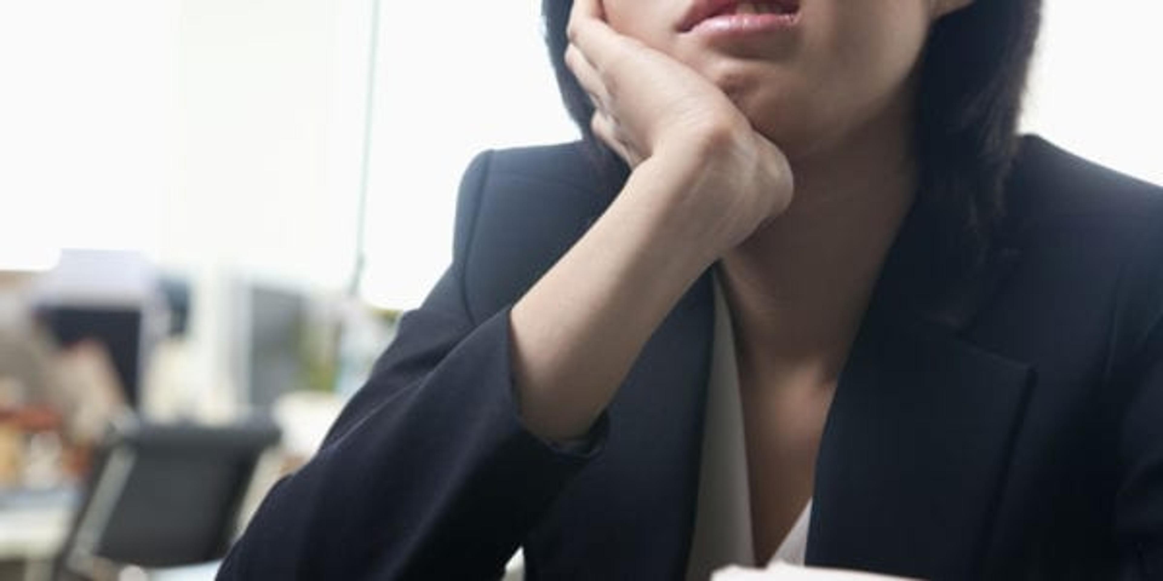 Image of a young woman bored at her desk