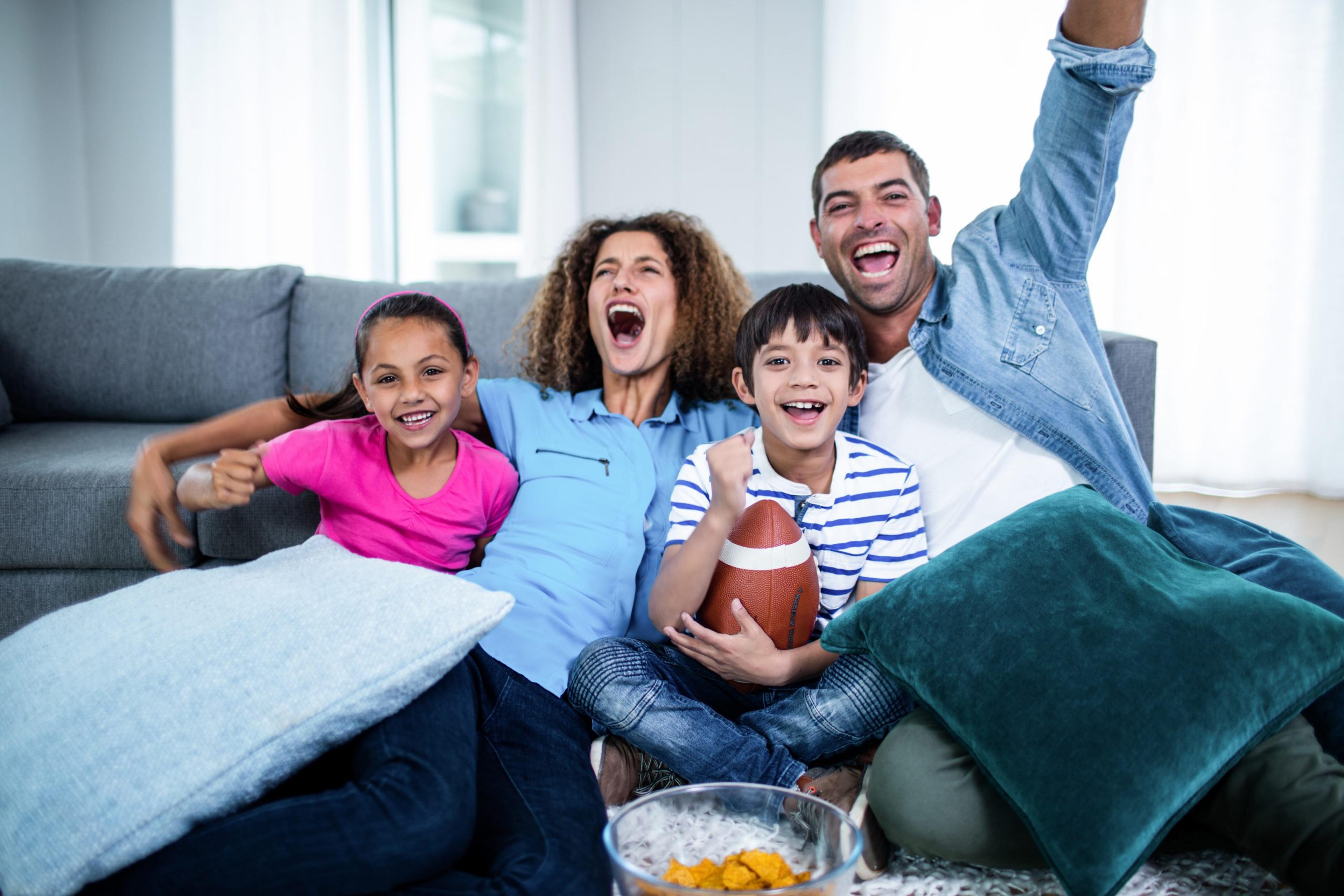 Family watching american football match on television at home