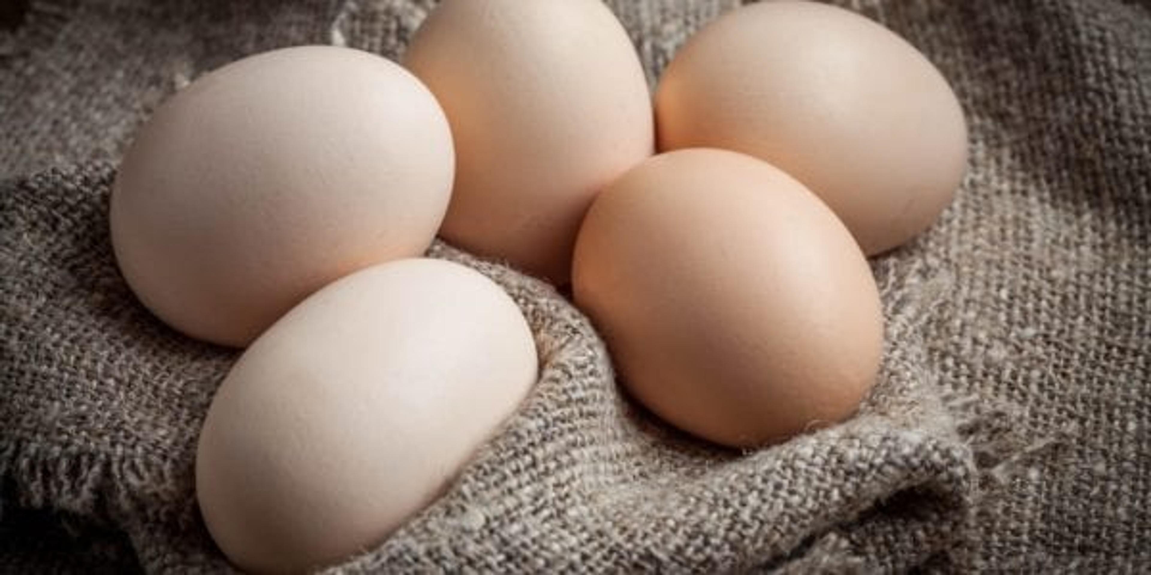 Raw organic farm eggs on the old background.