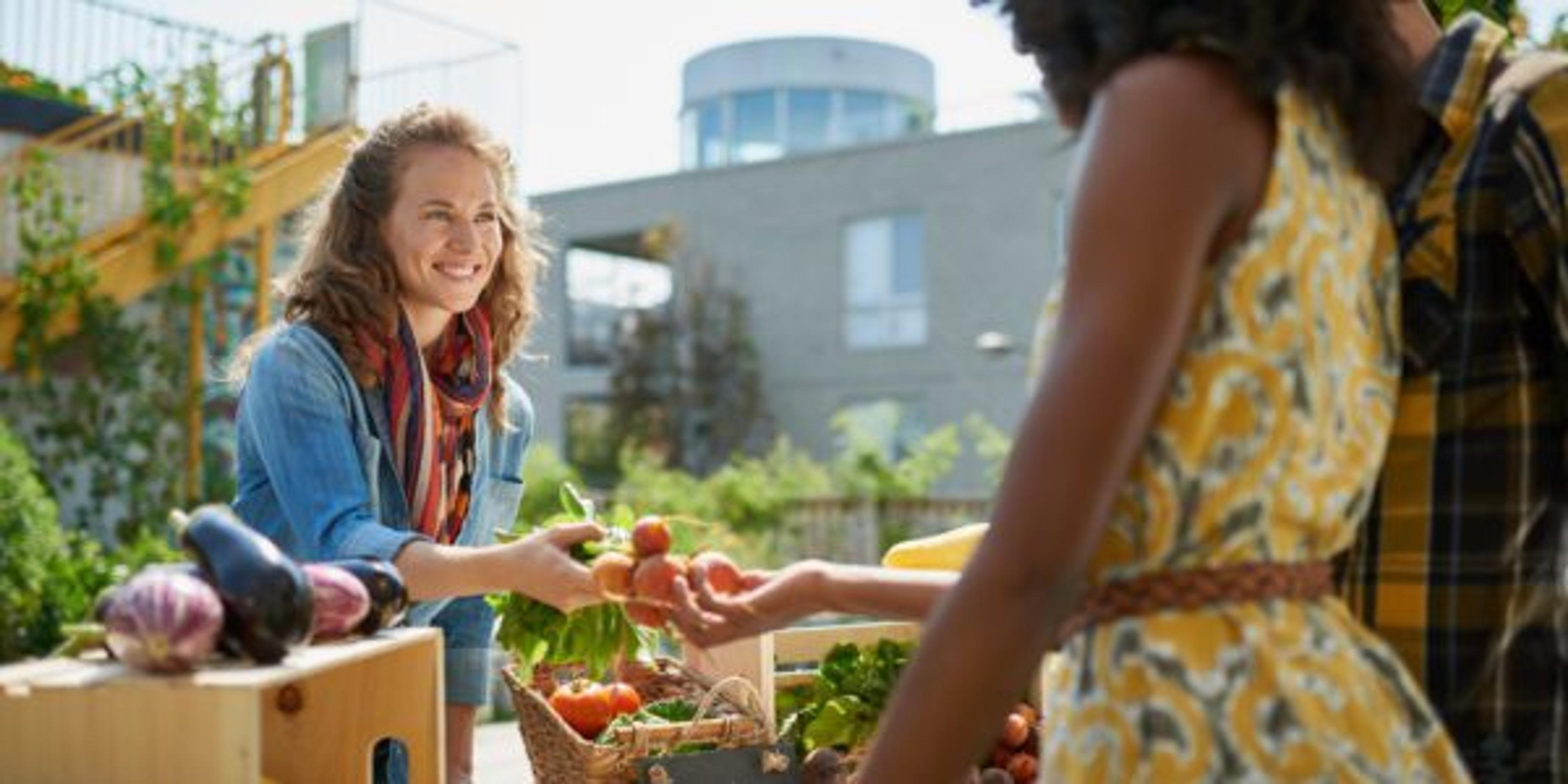 A farmer's market vendor and customer discuss produce.