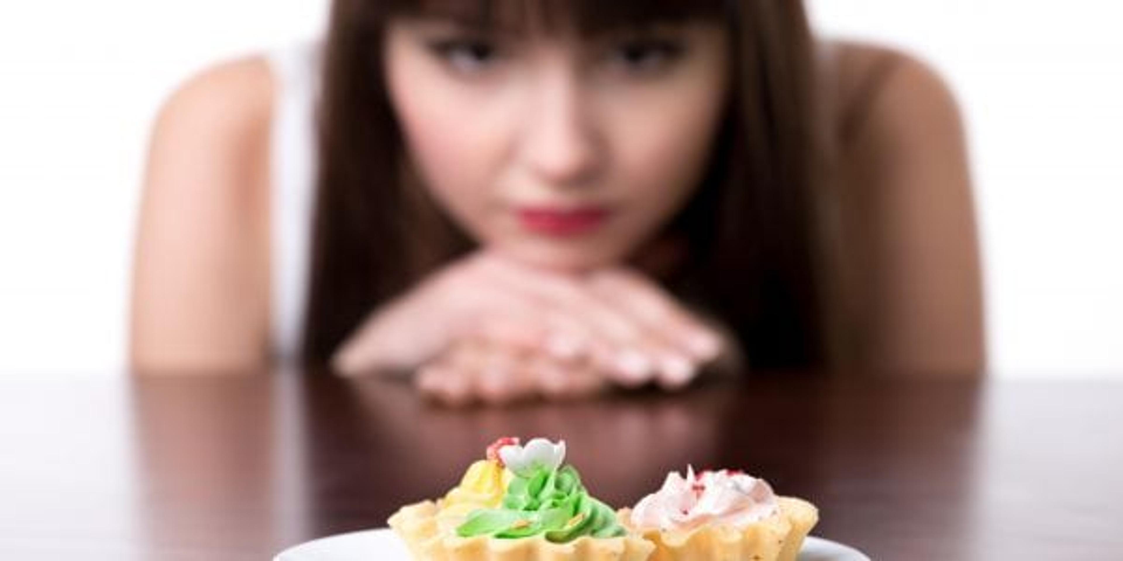 Young woman looking longingly at pastries.