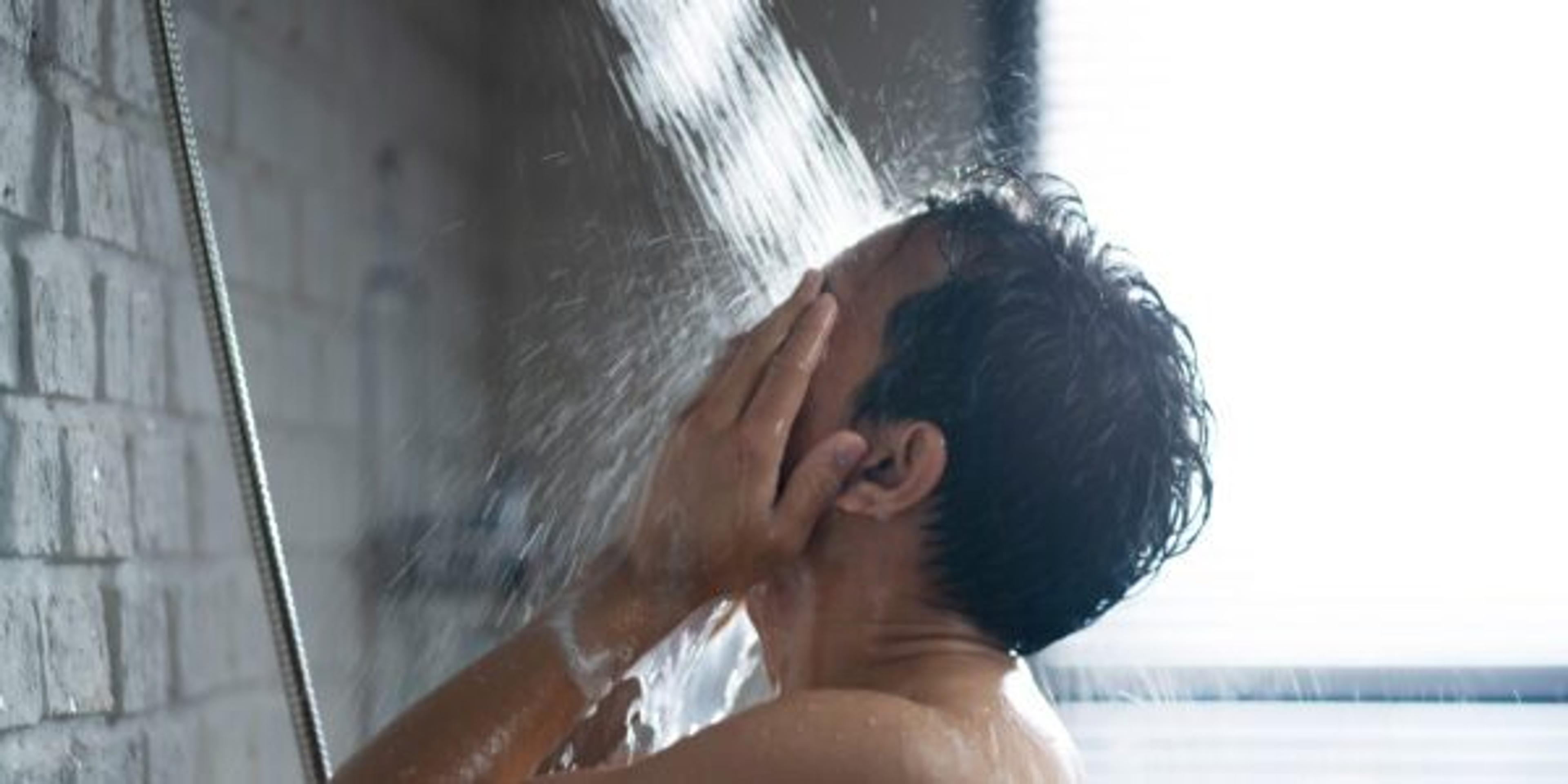 Handsome asian guy Taking a shower in the bathroom