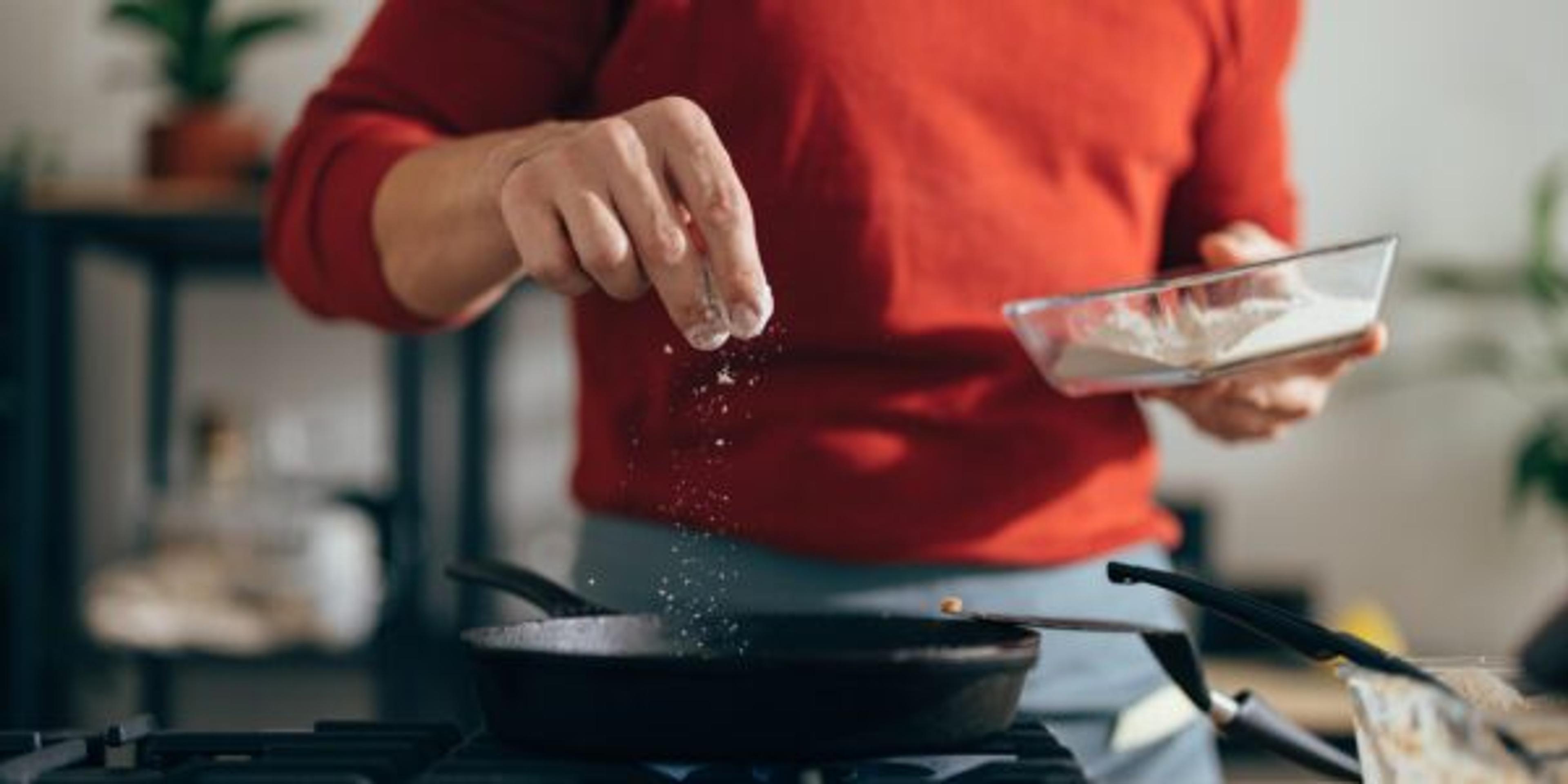 Close Up of Anonymous Man Adding Salt to a Meal