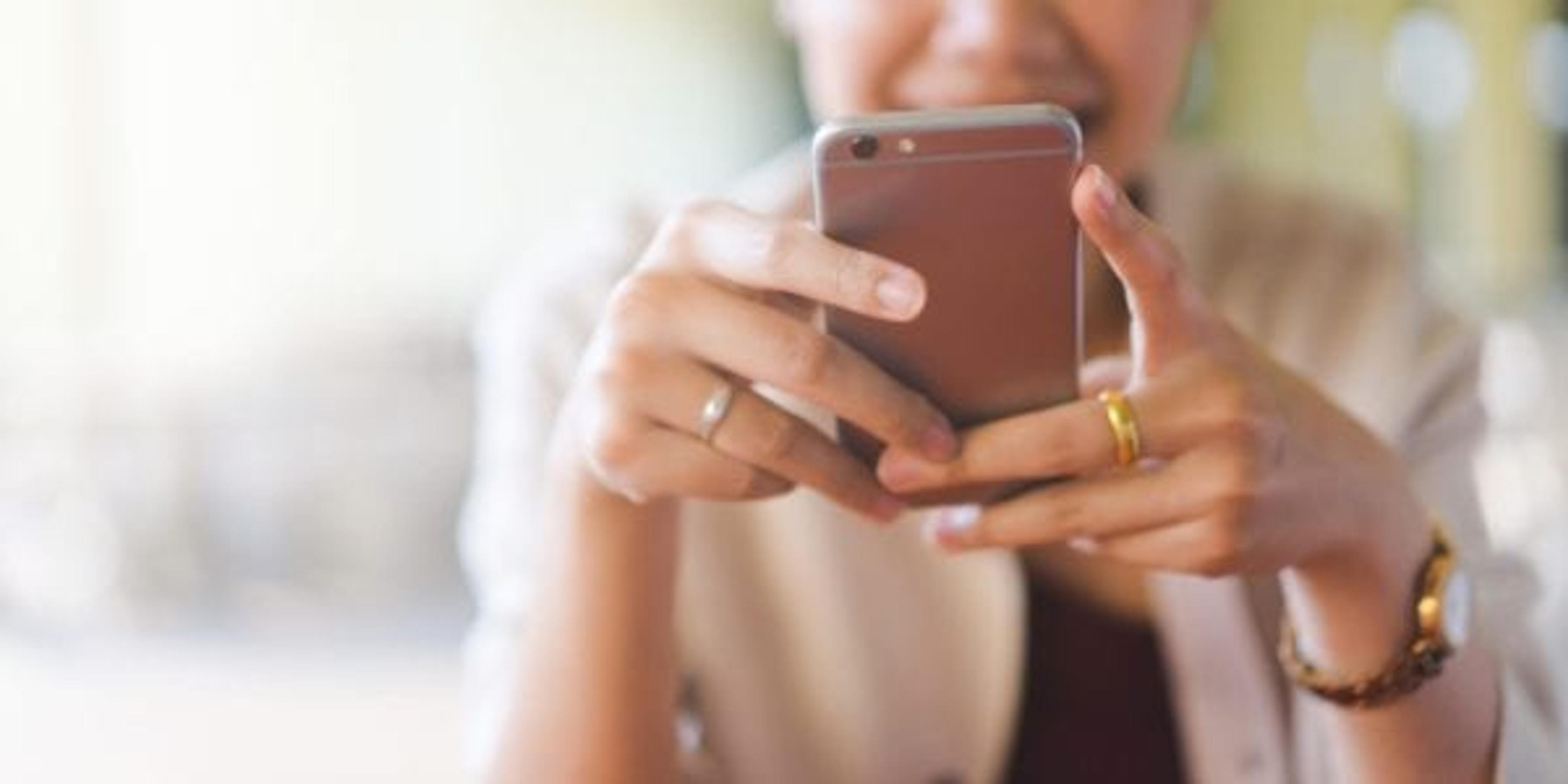 Woman looking at her phone smiling