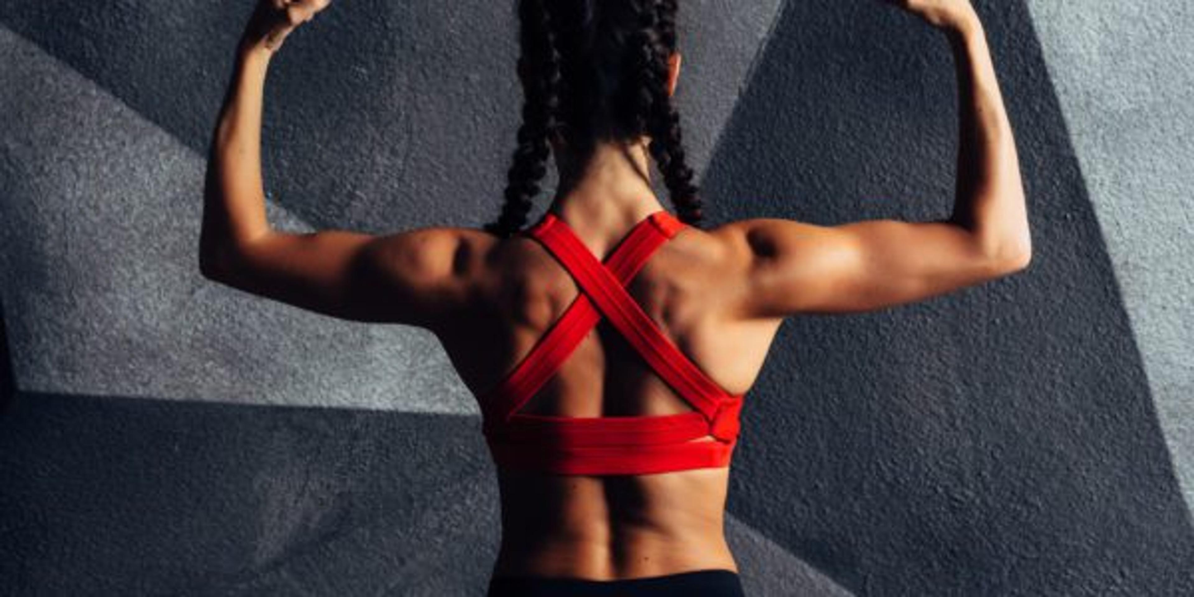 Back view portrait of a fitness woman showing biceps