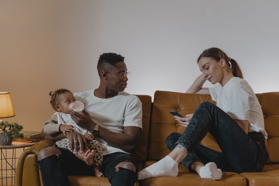 Tired new parents caring for their baby at home