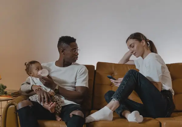 Tired new parents caring for their baby at home