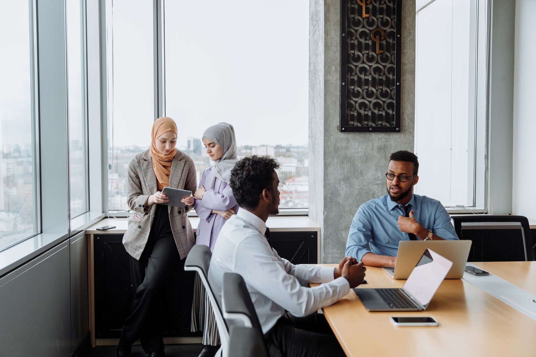 A diverse team in conversation by bright office windows