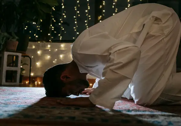 A man in prayer at home in the quiet of the evening