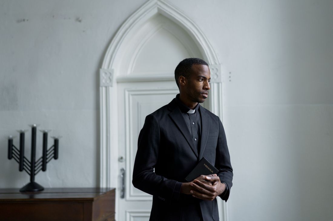 A pastor holding a Bible, deep in thought