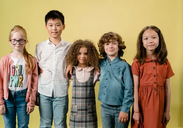 Five diverse children standing arm in arm, smiling