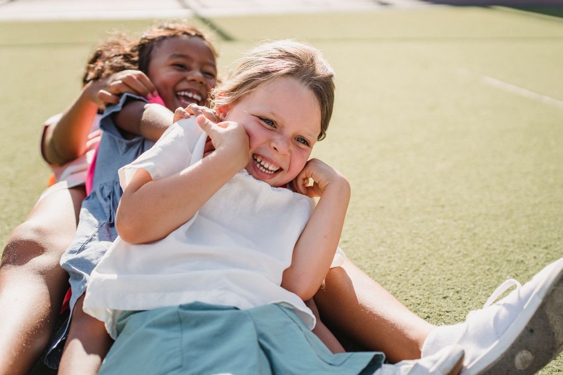Two children laughing together in the sunshine