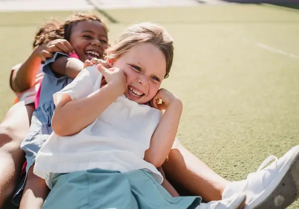 Two children laughing together in the sunshine